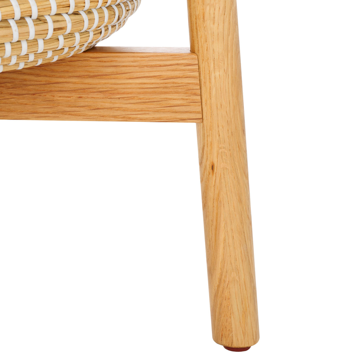 An angled natural wood leg and sturdy crossbar support the woven storage basket. || SFV4202A || leg_studio