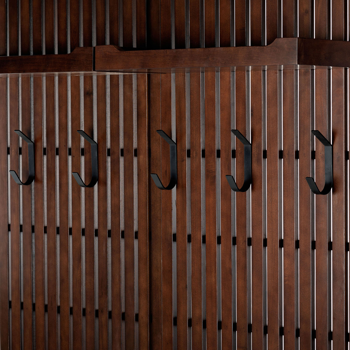 Black metal coat hooks line a warm wood slat back panel for organized outerwear || SFV4214A || detail_studio