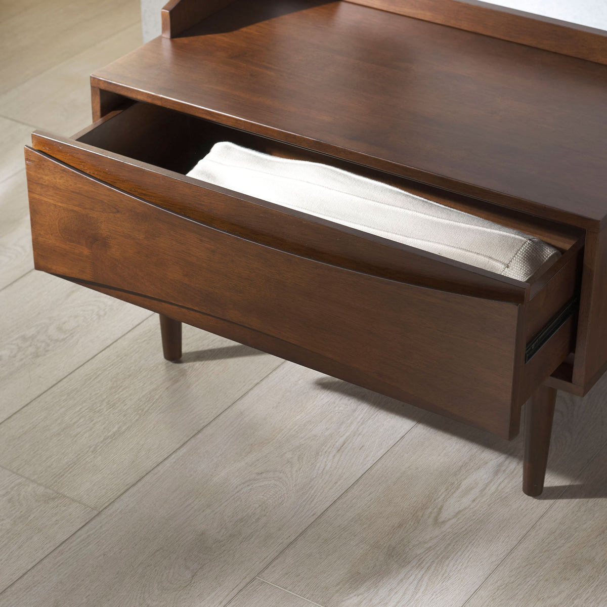 A roomy pull-out drawer holds folded linens and keeps entryway essentials neatly stowed.