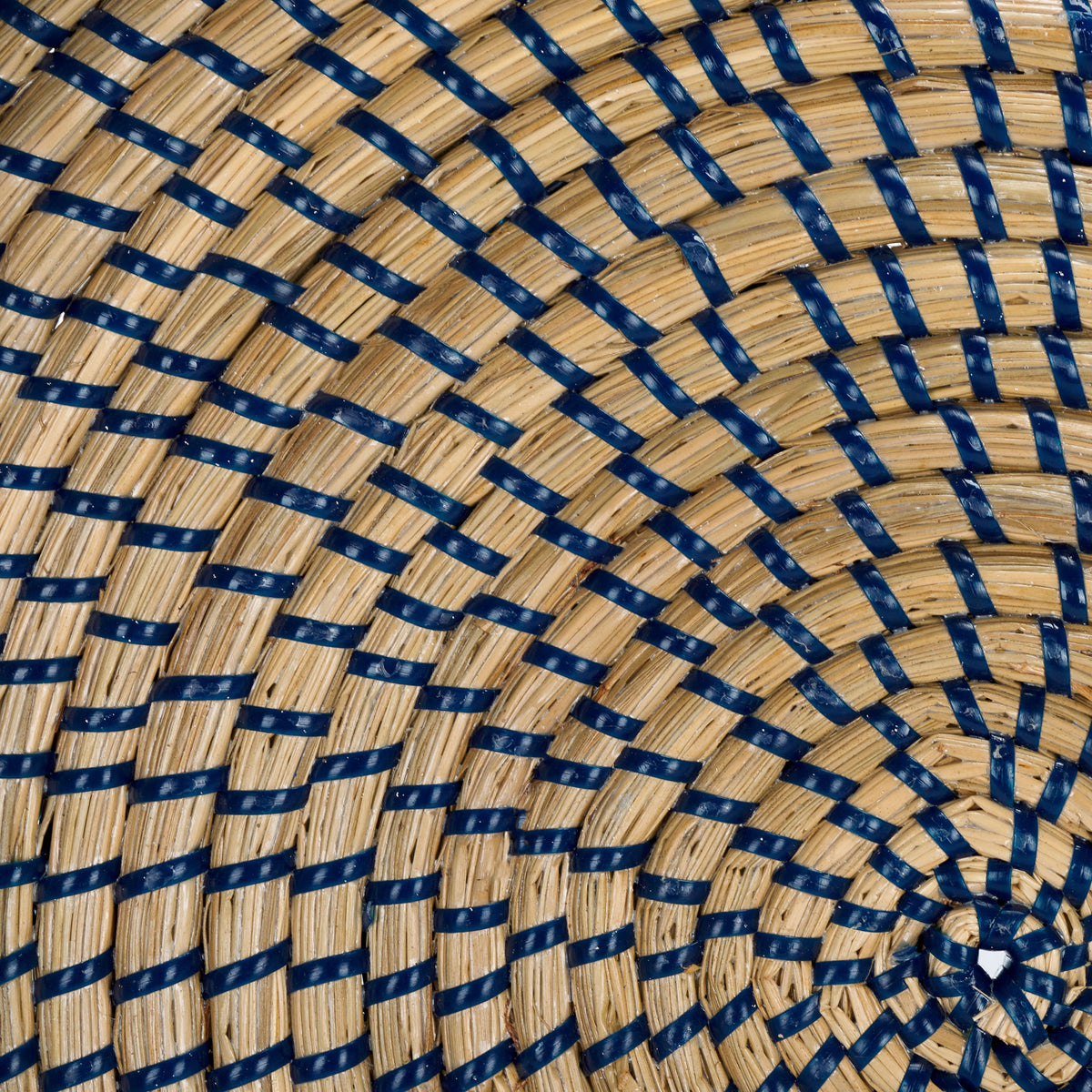 Blue strands weave through natural seagrass in a radiating pattern across the tray base. || STG1809A || swatch_studio
