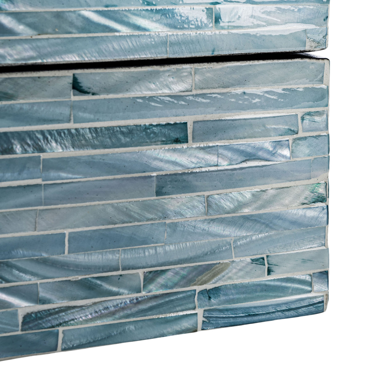 Iridescent shell tiles vary from silvery gray to deep blue across a decorative box's lower corner.