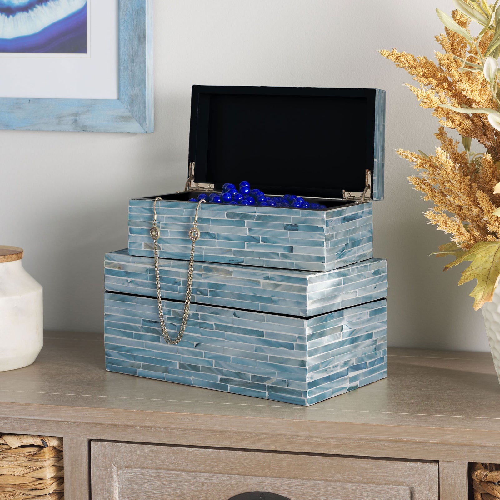 An open blue-gray mosaic box holds jewelry above a matching larger keepsake box. || STG1812A || front_angle_open_room