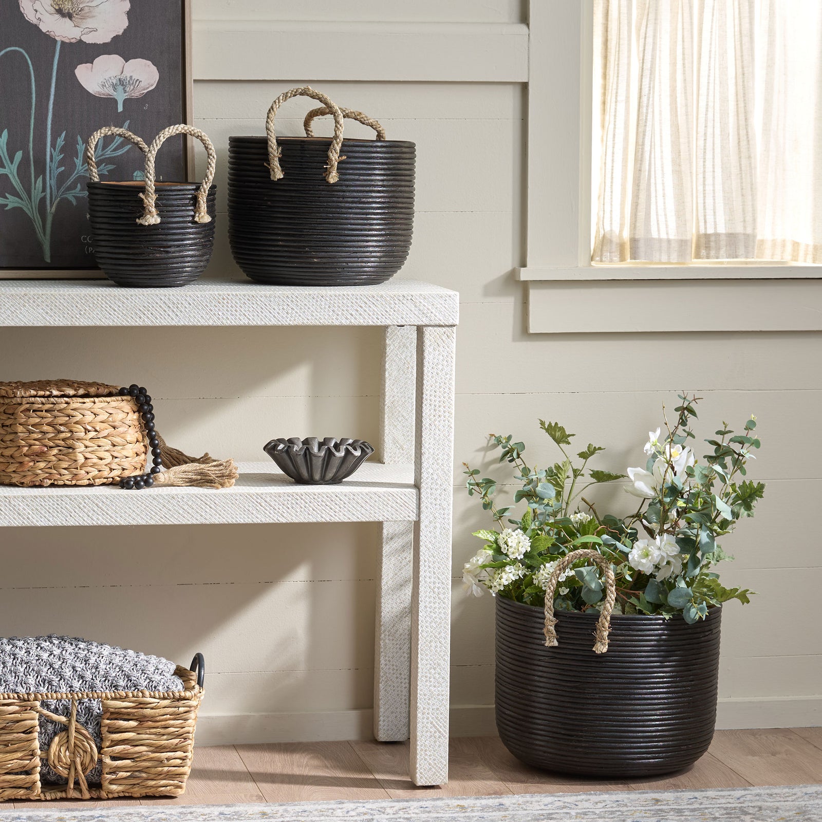 Graduated black baskets bring woven texture to shelves, with the largest holding greenery || STG1816A || front_room