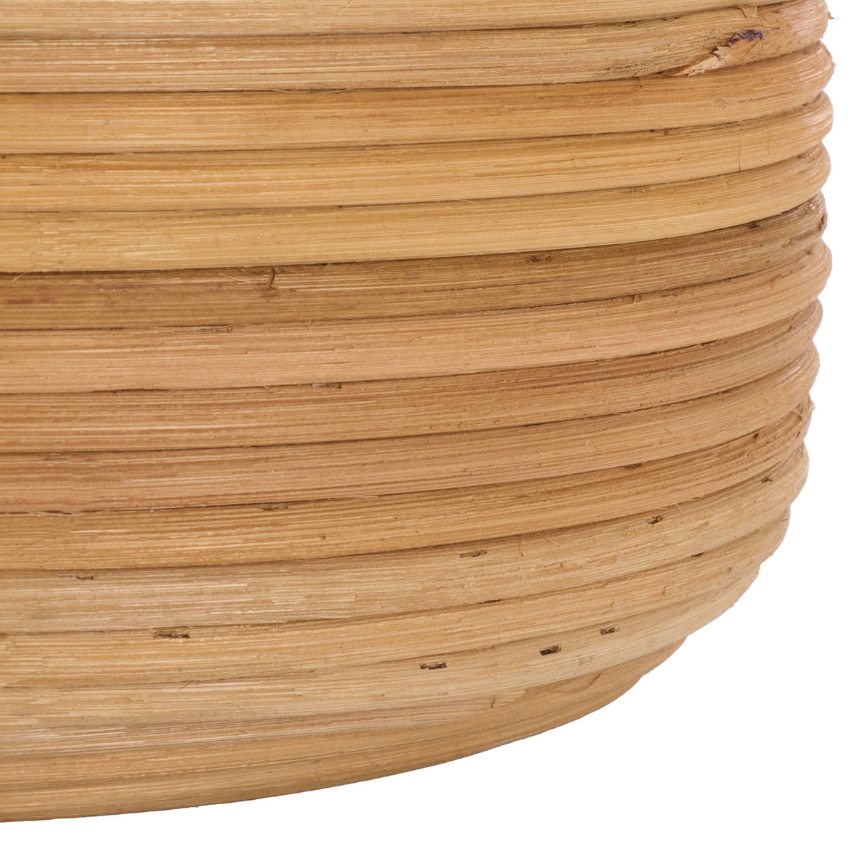 The basket's rounded lower edge reveals layered rattan coils and warm natural tones.