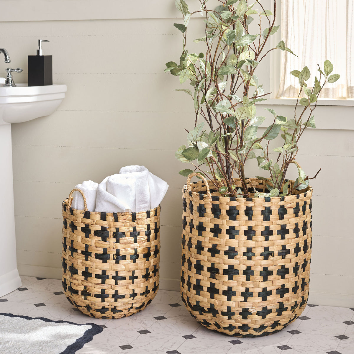 A pair of woven baskets holds plush towels and leafy greenery in a bright bathroom. || STG1829A-SET2 || front_room
