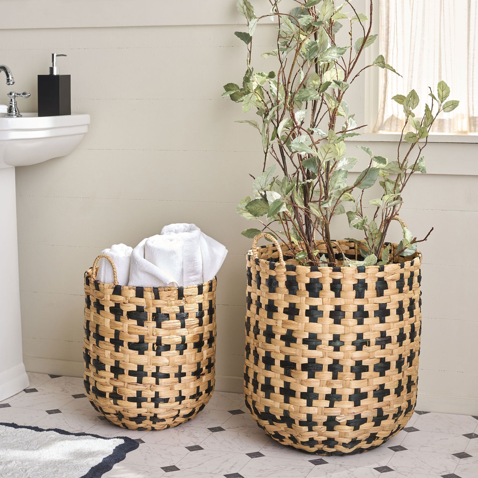 A pair of woven baskets holds plush towels and leafy greenery in a bright bathroom. || STG1829A-SET2 || front_room