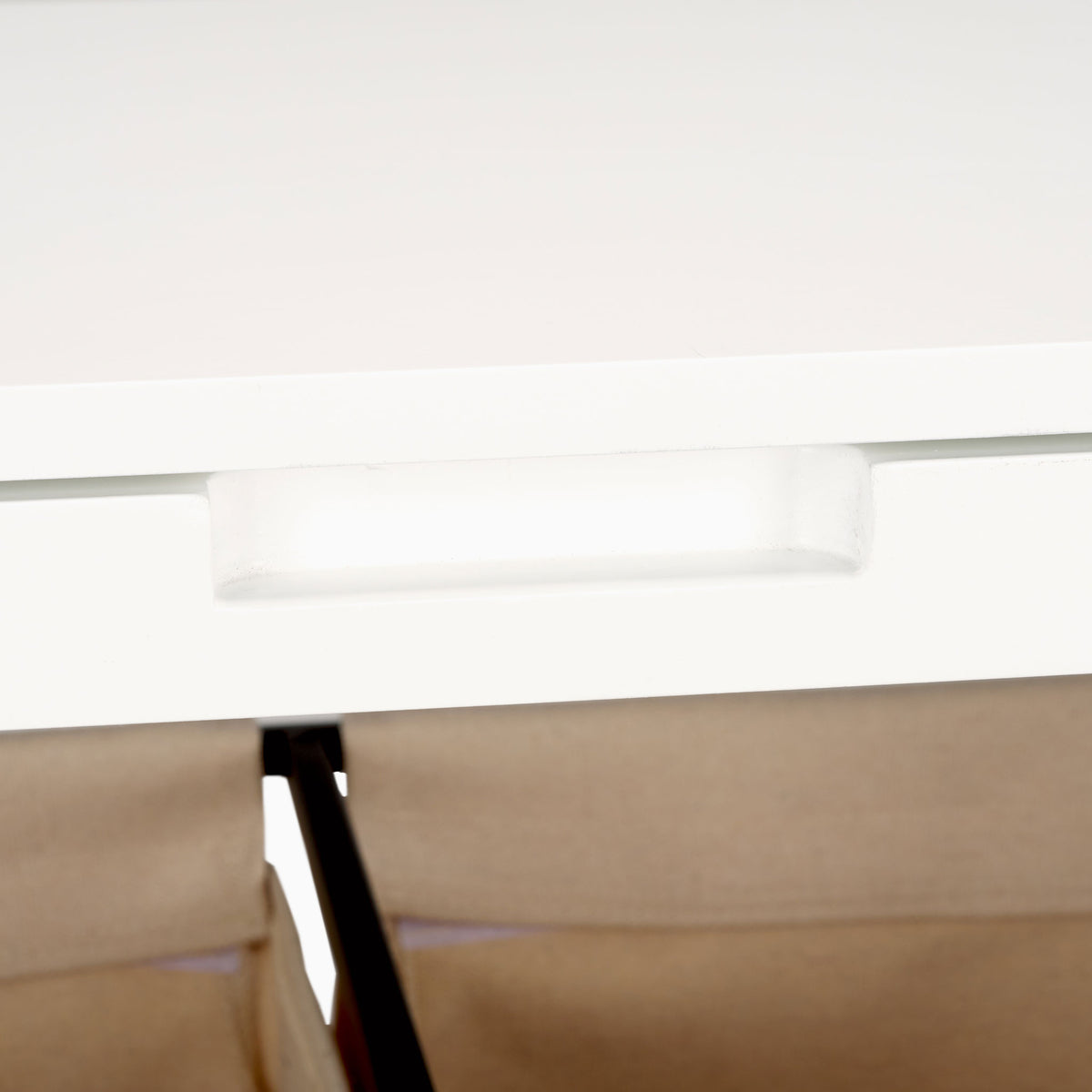 A low-profile white handle blends into the lid above the beige fabric laundry compartments. || STG1900A || handle_studio