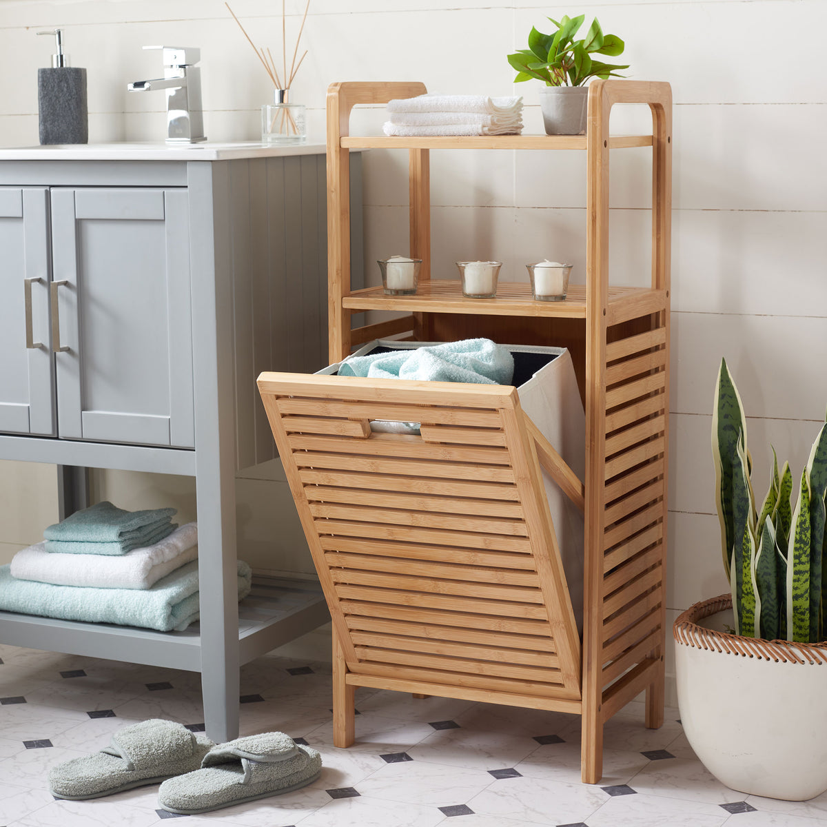 A pull-down hamper holds towels below bamboo shelves displaying bath essentials and greenery || STG1903A || front_angle_open_room