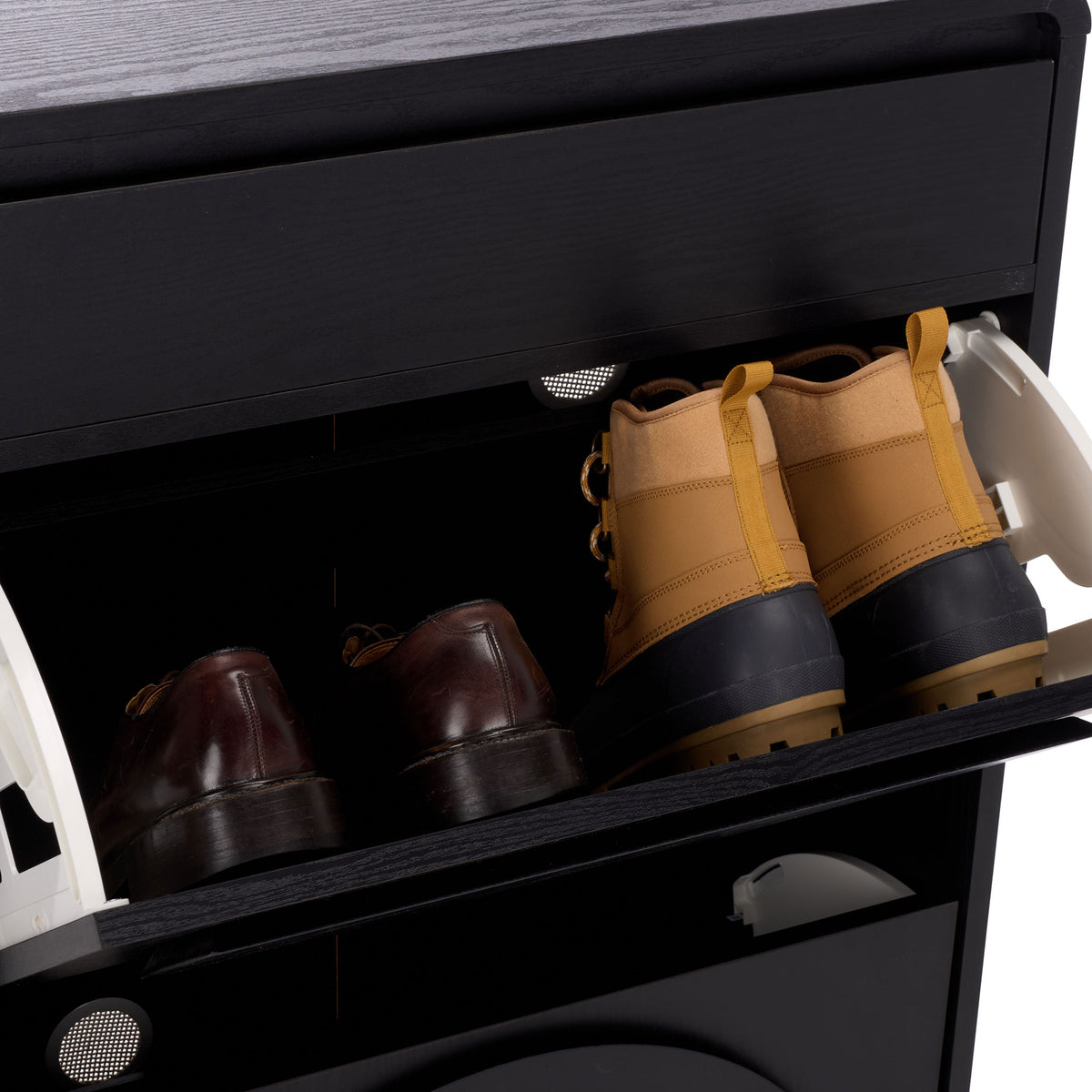 A tilt-out shoe bin accommodates boots and dress shoes within the black cabinet. || STG3100B || storage_open_studio
