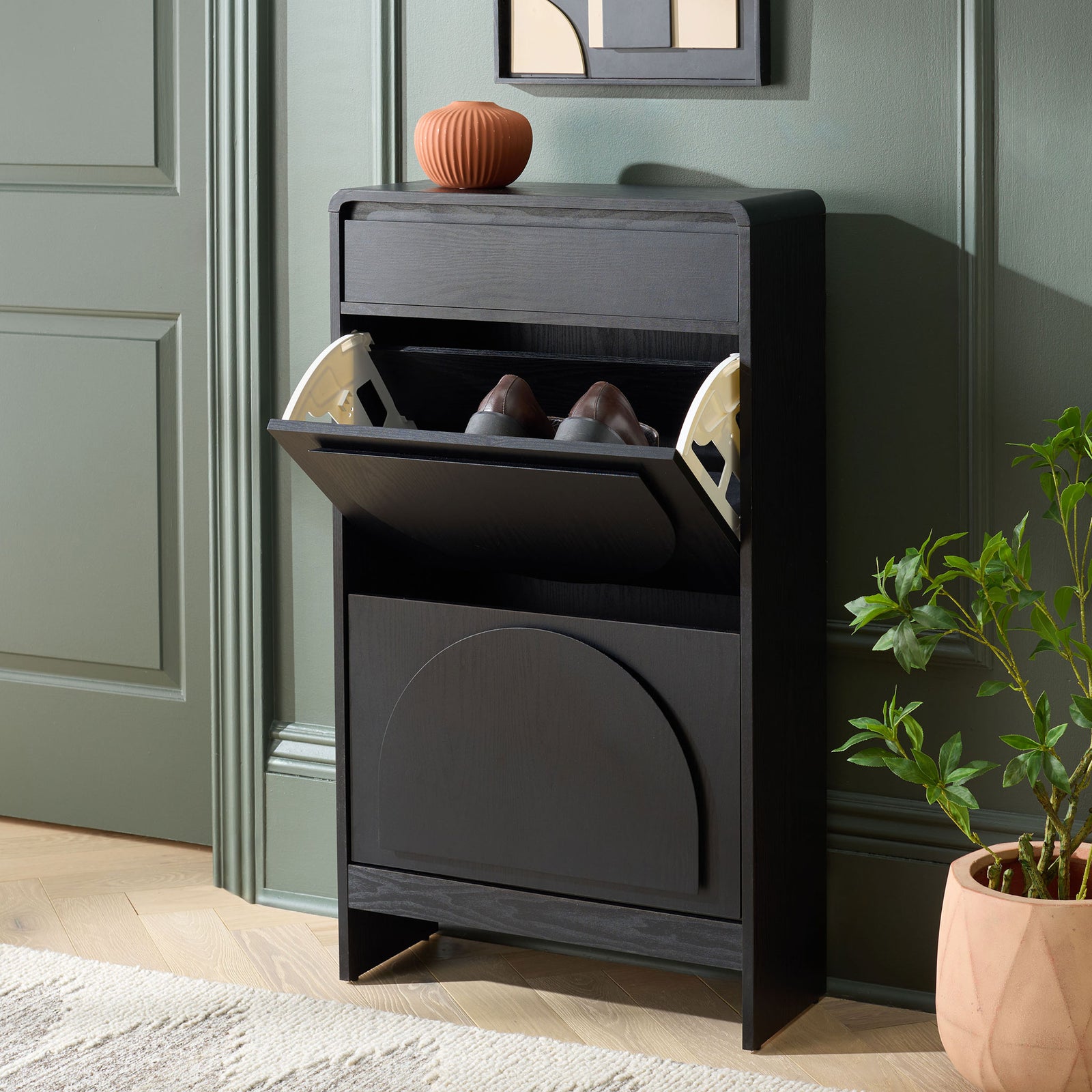 An open tilt-out shoe compartment adds easy-access storage to this slim black cabinet. || STG3100B || front_angle_open_room
