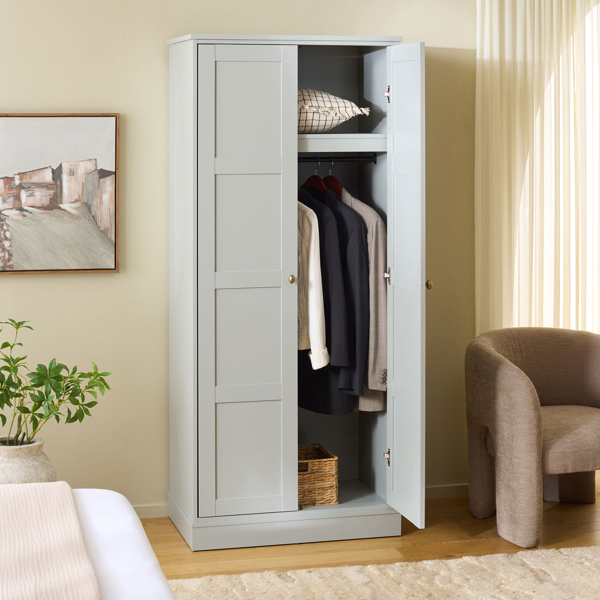 An open paneled door reveals hanging clothes, a top shelf, and basket space below. || STG3102A-2BX || front_angle_open_room