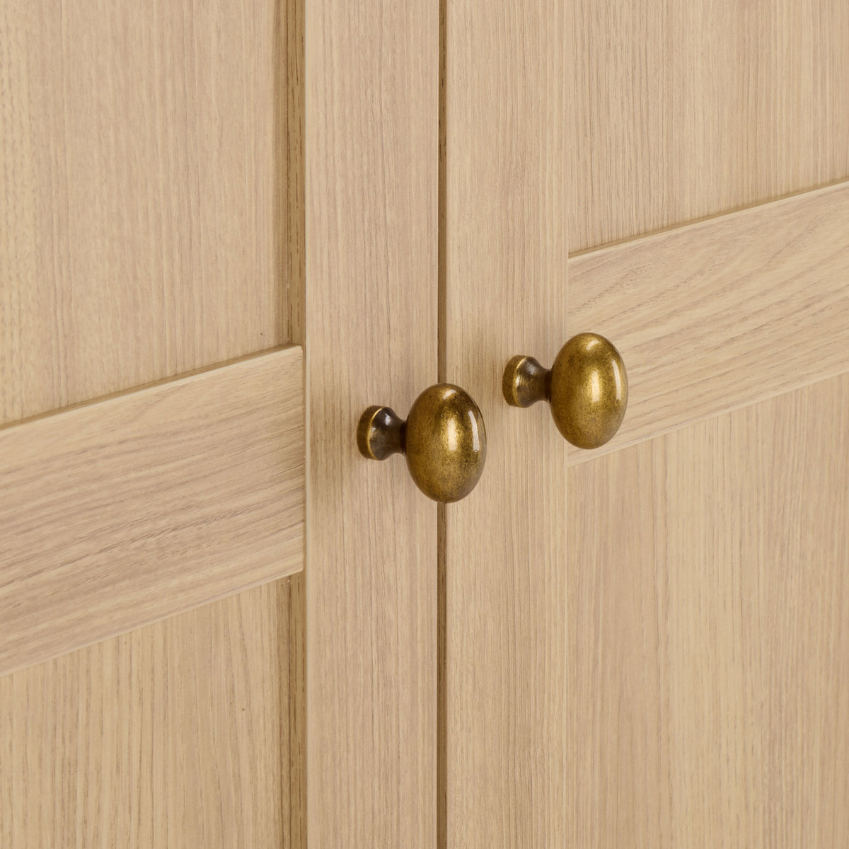 Two brass-tone knobs add a warm metallic accent to natural wood-look paneled doors. || STG3103B-3BX || handle_studio