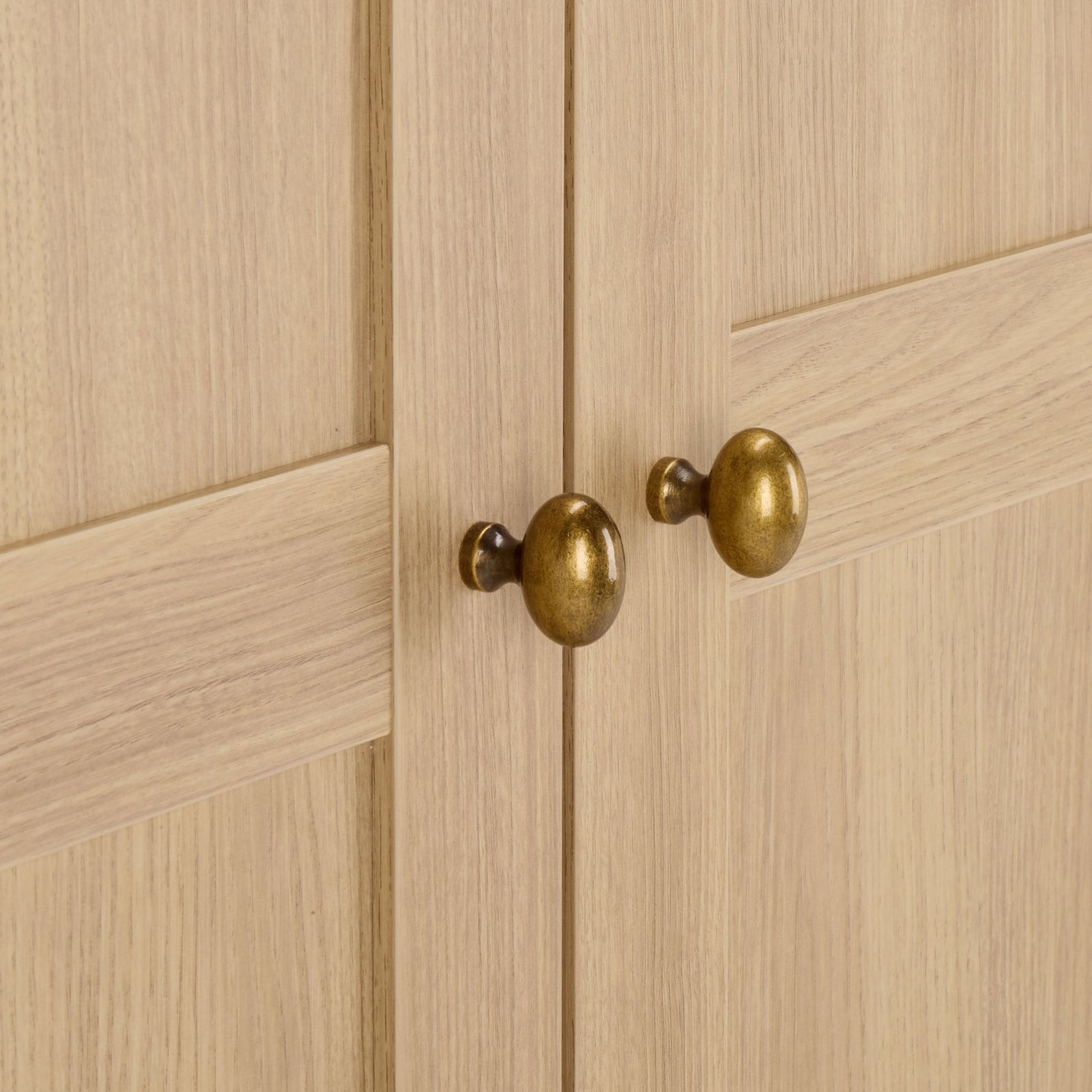 Two brass-tone knobs add a warm metallic accent to natural wood-look paneled doors. || STG3103B-3BX || handle_studio