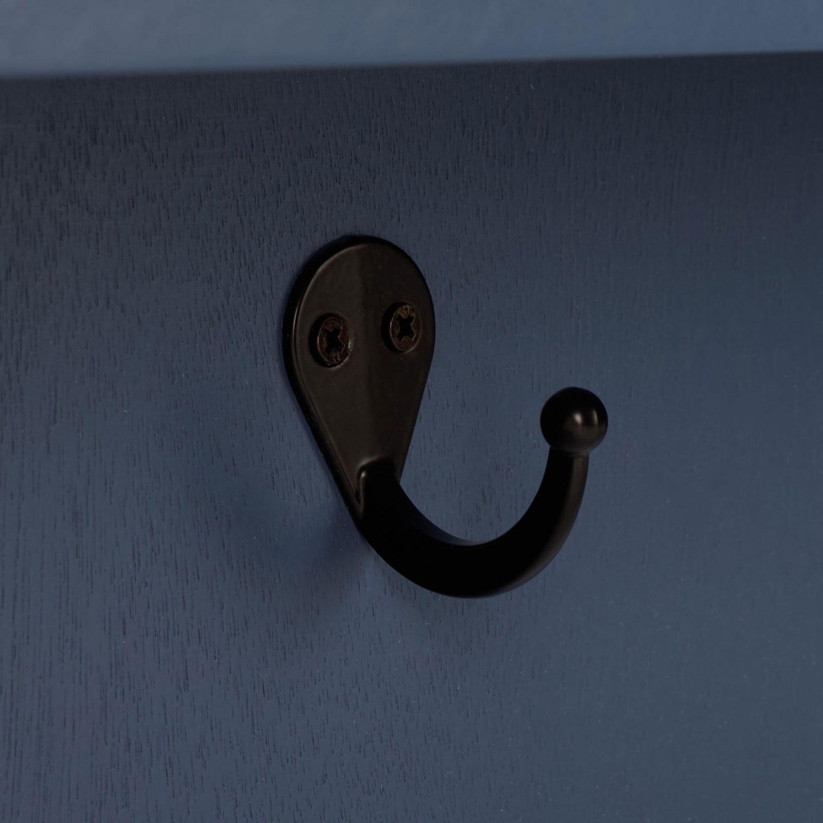 A curved black metal hook contrasts with the blue painted wood grain || STG5702D || detail_studio