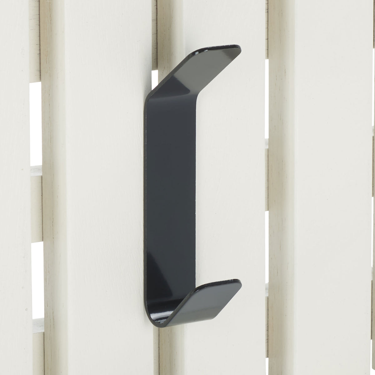 A black double hook stands out against clean white wood slats, adding two spots for hanging essentials. || STG5704C || detail_studio