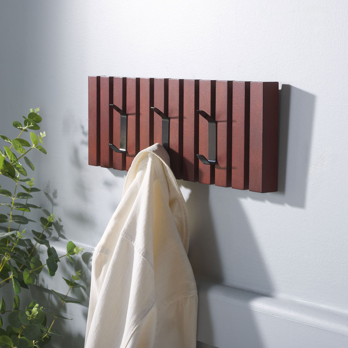 A cream robe hangs from the cherry-finished rack, with two black hooks left ready for more. || STG5704H || front_angle_room