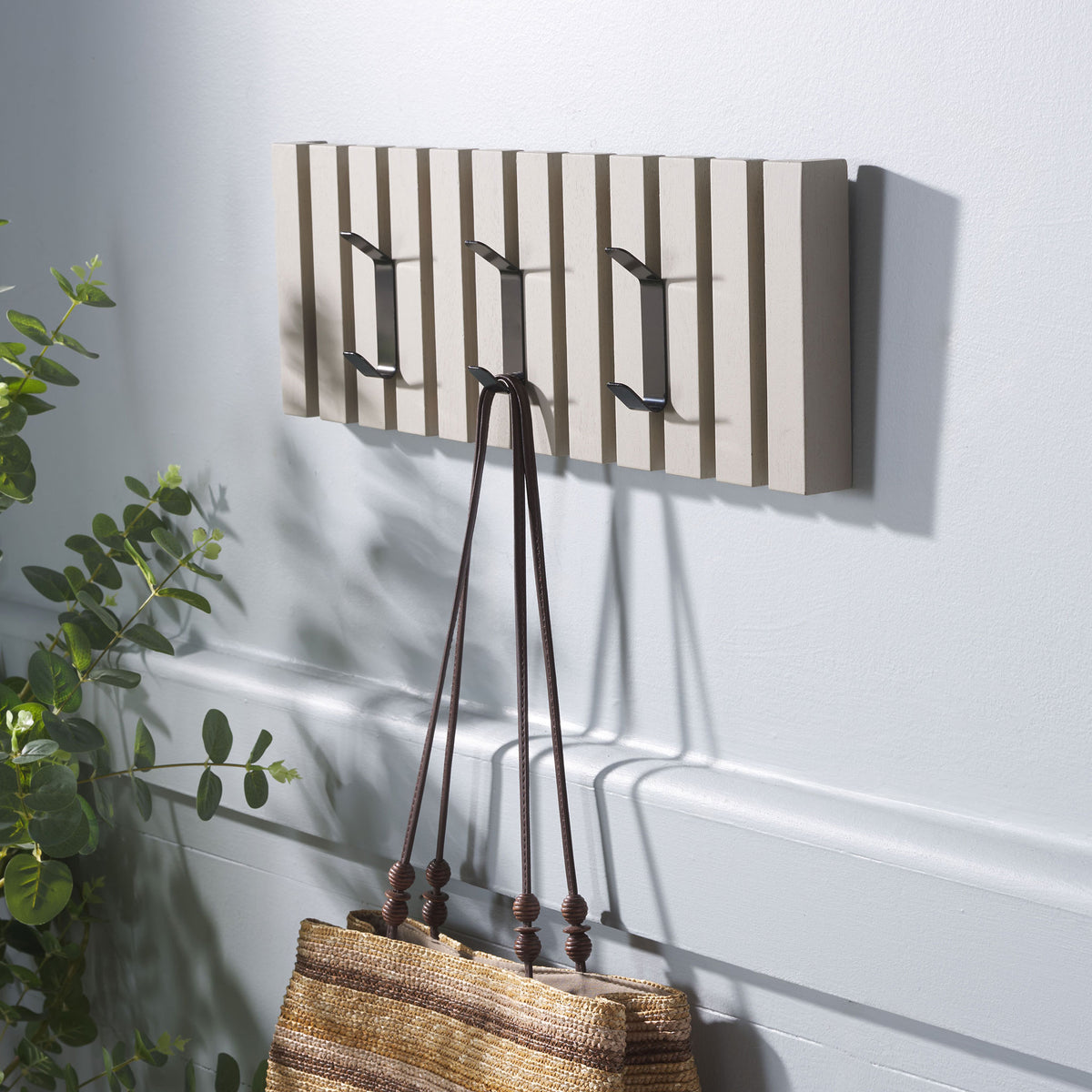 A woven tote hangs from the vintage gray rack, with two open metal hooks for coats or hats. || STG5704J || front_angle_room