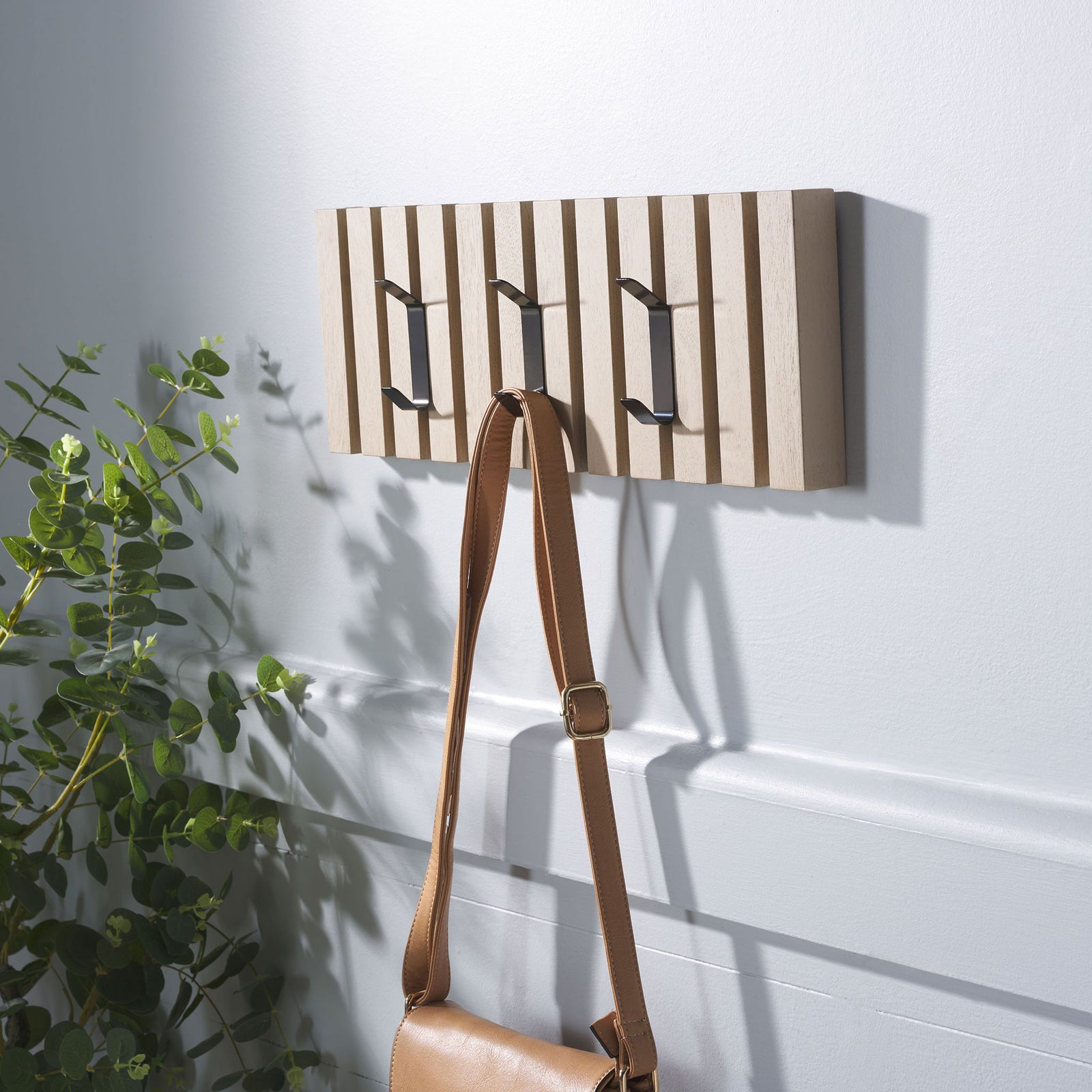 A tan shoulder bag hangs from the sand-finished rack, with two extra hooks ready for jackets or hats. || STG5704N || front_angle_room