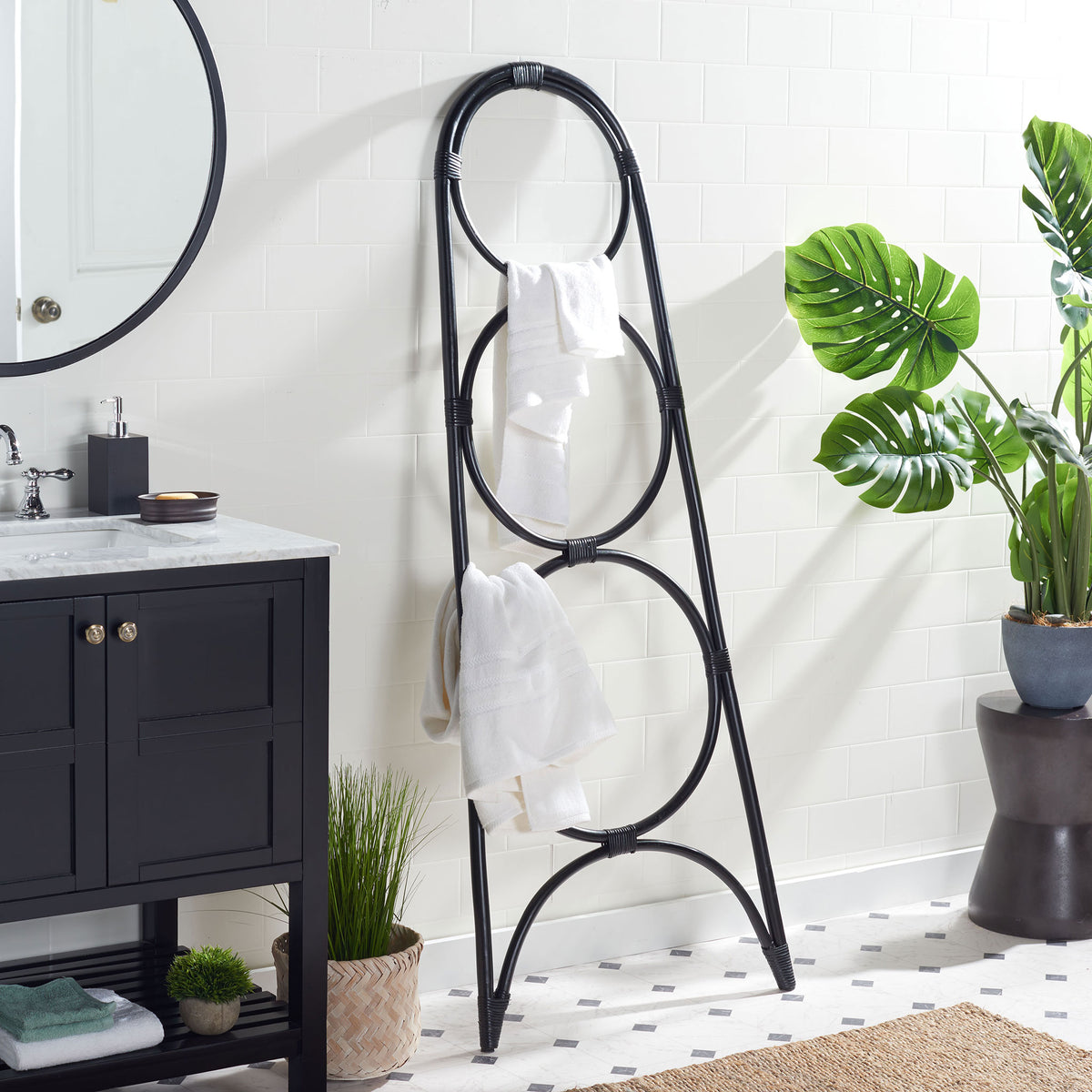 Black rattan towel stand holds white bath linens on its open circular rails. || STG6501B || side_room