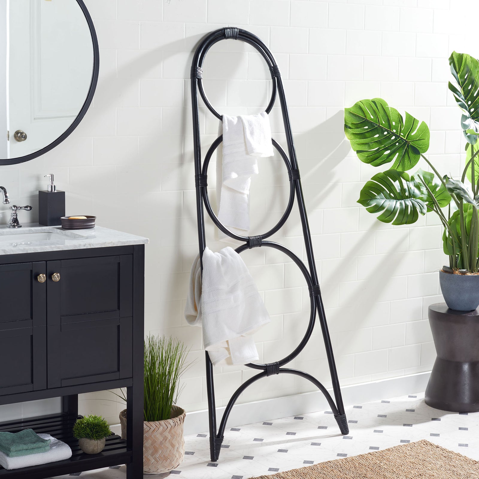 Black rattan towel stand holds white bath linens on its open circular rails. || STG6501B || side_room