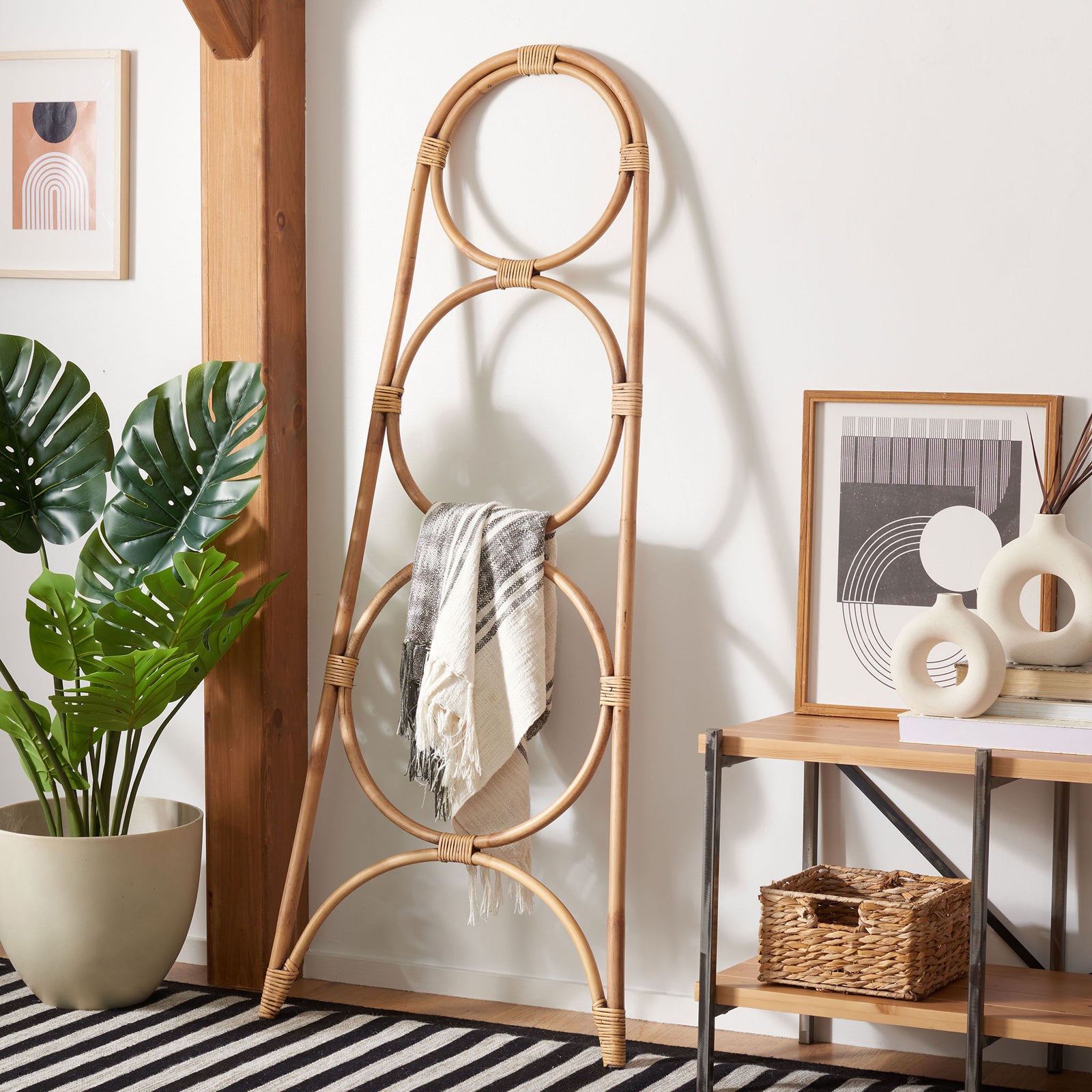 Honey-brown rattan rings hold a draped gray-and-white throw within an airy frame. || STG6501C || front_angle_room