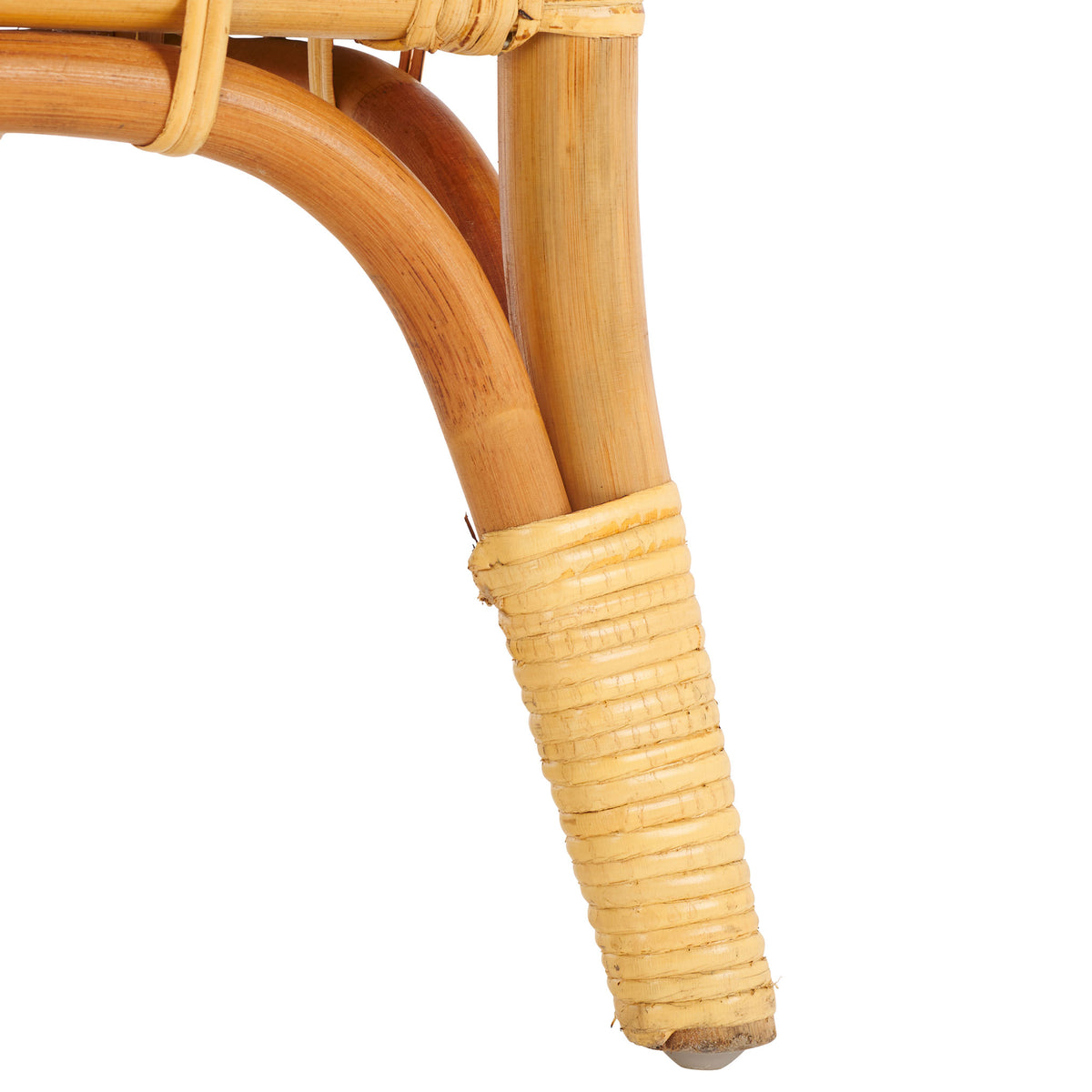 Warm natural rattan flares into a wrapped foot beneath a gently curved support