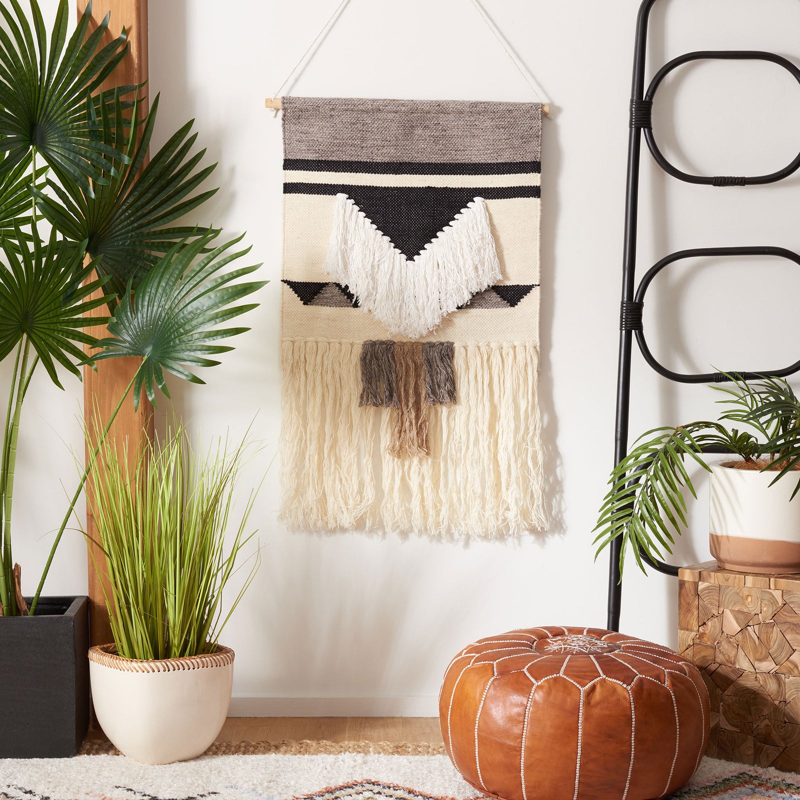 Black geometric bands frame the ivory wool-and-bamboo wall hanging with V-shaped fringe and soft tassels. || SWA145Z-2 || front_room