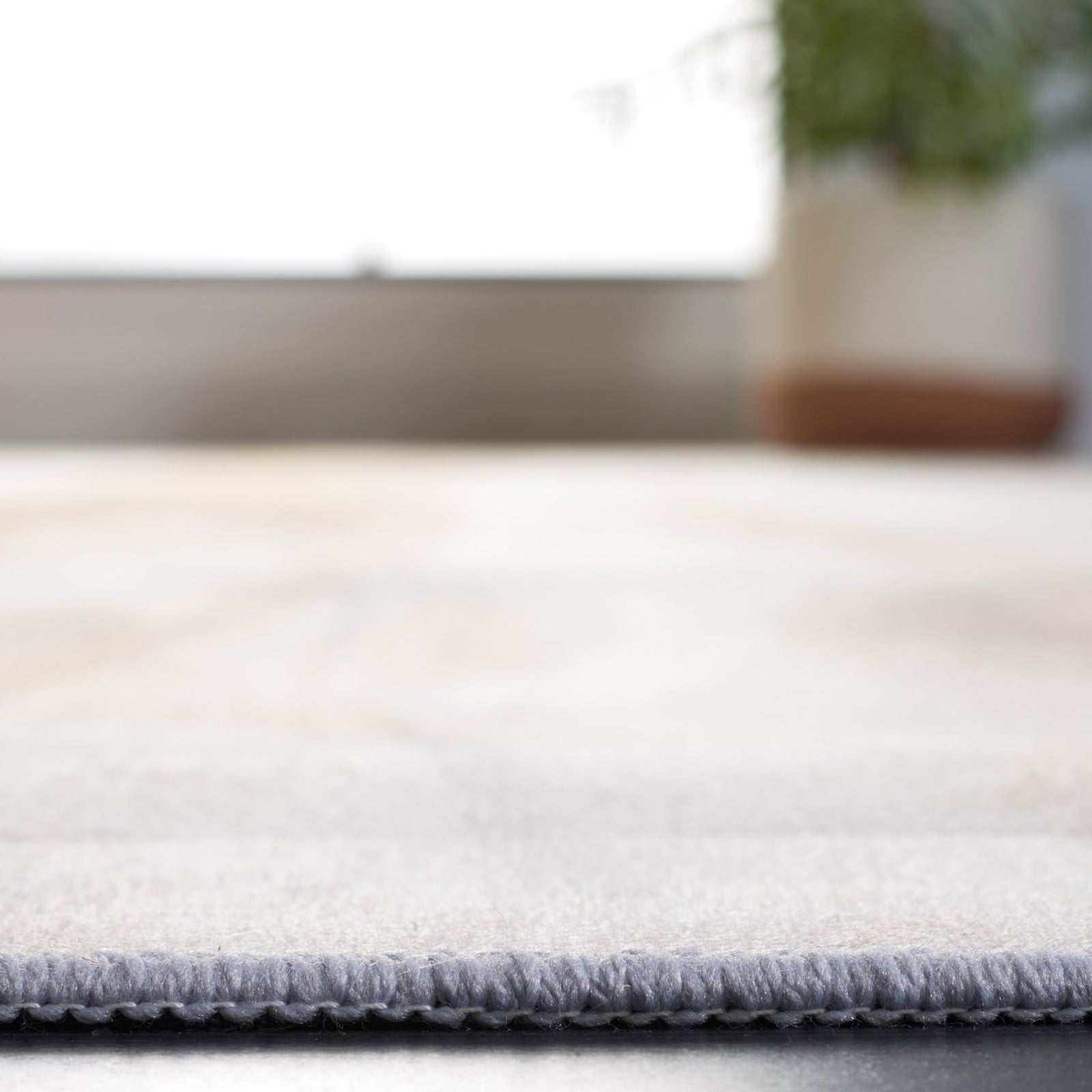 Low-profile rug with a smooth edge and soft fiber surface. || TAC807B-5 || detail_room