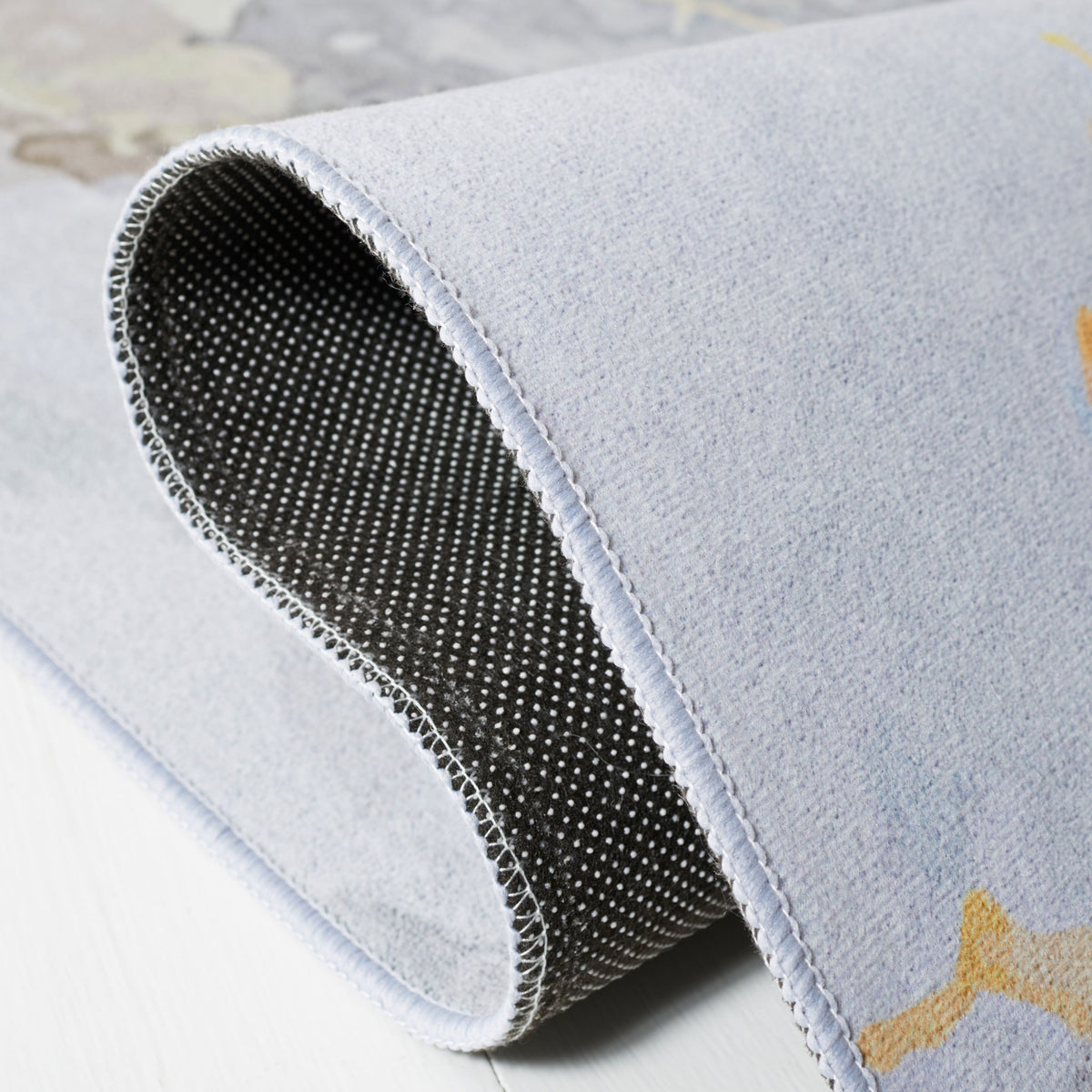 Folded corner reveals slip-resistant dotted backing and smooth, flexible pile || TAC811F-5 || backing_studio