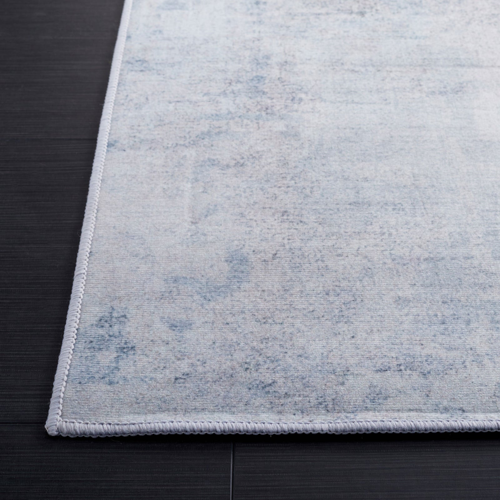 Neatly serged edge and subtle mottled pattern in gray and blue elevate the rug's refined look || TAC833F-5 || corner_room