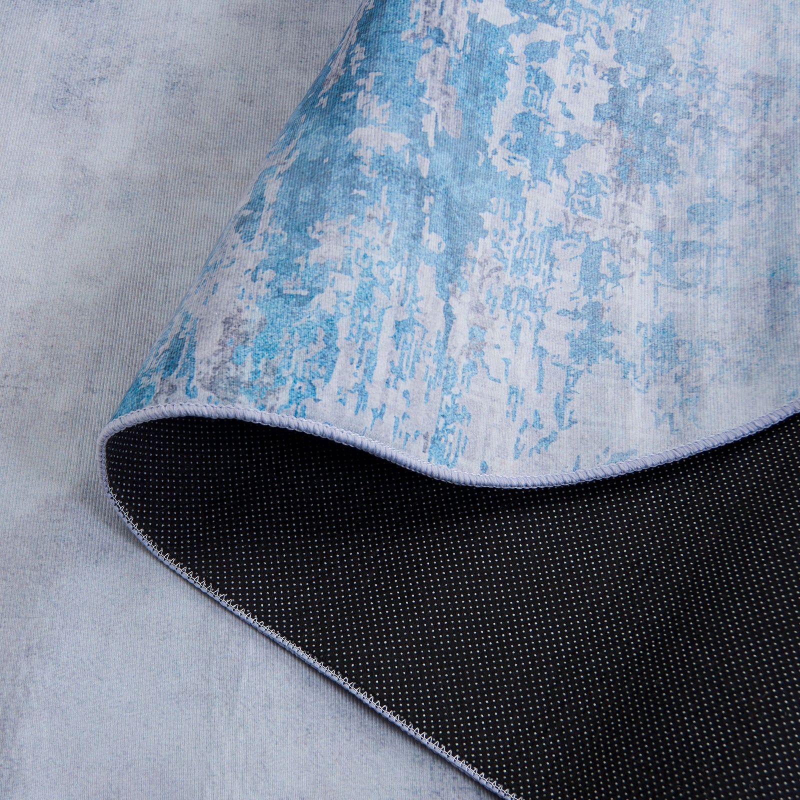 Slip-resistant dot backing and flexible, low-profile design for a stable, washable rug || TAC833F-5OV || backing_studio
