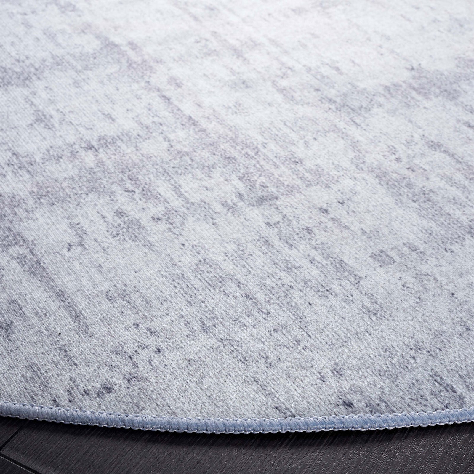 Heathered texture and neatly serged edge lend a refined finish to this low-profile round rug || TAC857F-6R || detail_room