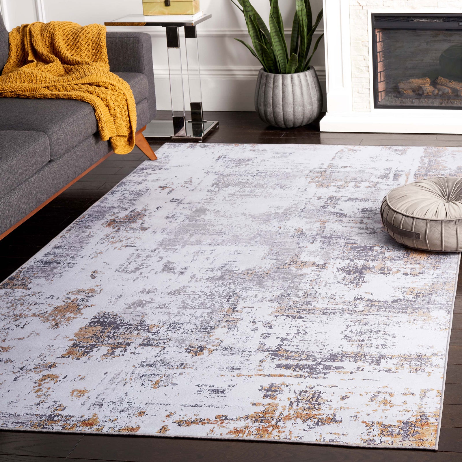 Abstract gray and gold rug styled in a living room with a softly distressed modern pattern. || TAC863F-5 || front_angle_room