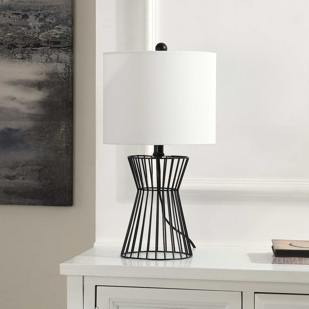 Sculptural black iron lamp with crisp white shade adds modern polish to consoles and nightstands || TBL4471A || front_angle_room