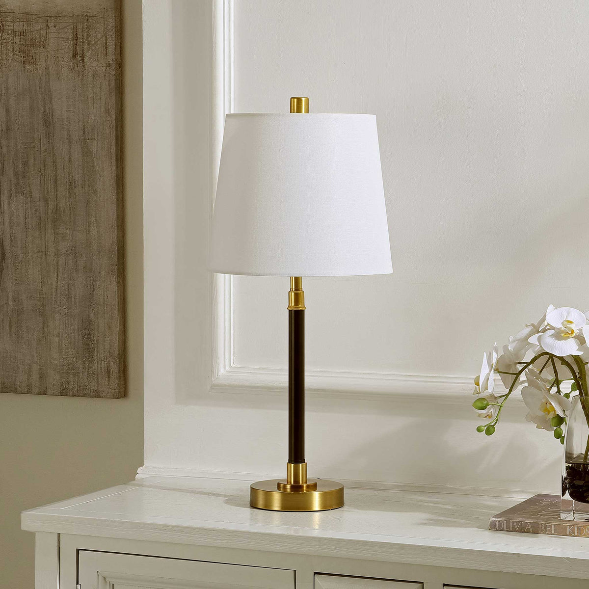Black-and-brass lamp with a crisp white shade brings refined contrast to any console or bedside || TBL4475A || front_angle_room