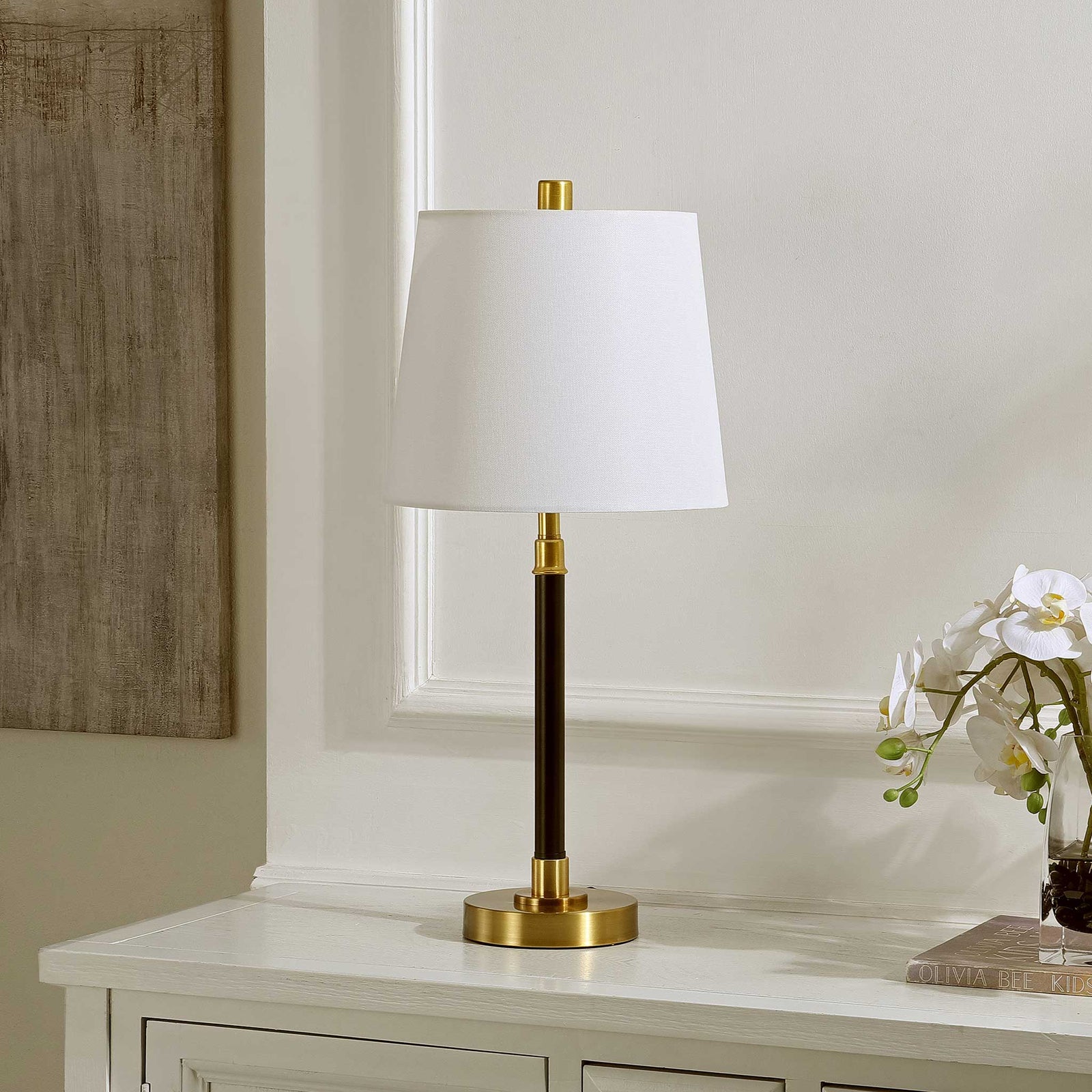 Black-and-brass lamp with a crisp white shade brings refined contrast to any console or bedside || TBL4475A || front_angle_room