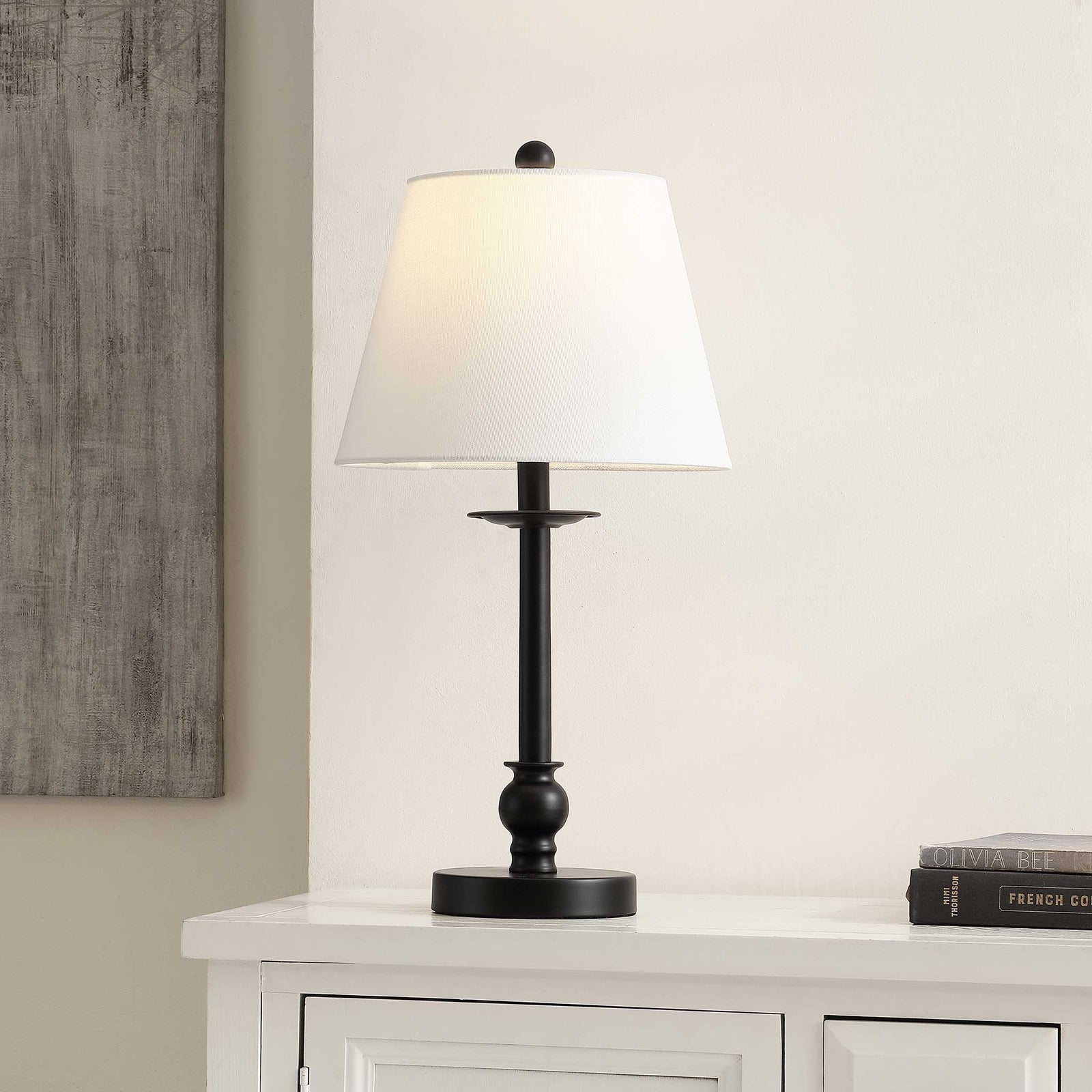 Warm-lit black table lamp softly brightens the room with its classic white shade || TBL4502A || front_on_room