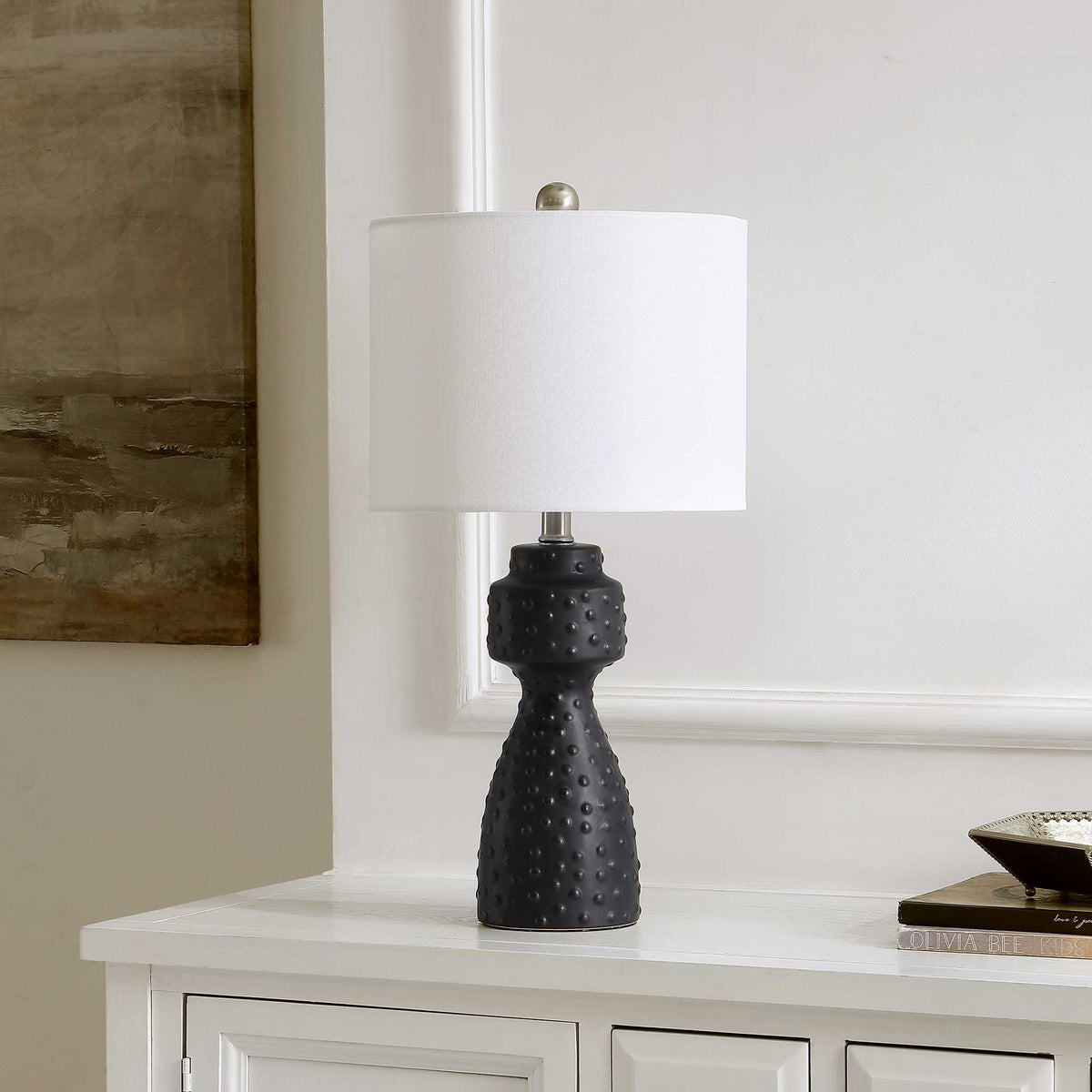 Sculptural black ceramic lamp with studded texture and white shade adds modern polish to decor || TBL4511A || front_angle_room