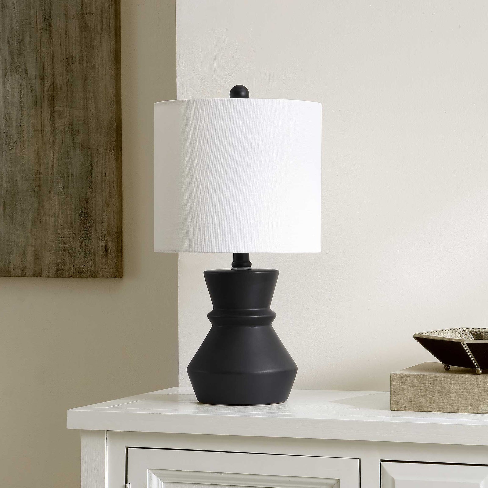 Modern black ceramic lamp adds sleek contrast with its white shade on a console table. || TBL4515A || front_angle_room