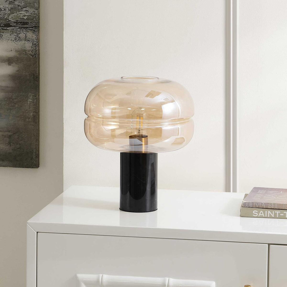 Sculptural amber glass lamp with glossy black marble base brings modern warmth to any space. || TBL4518A || front_angle_room