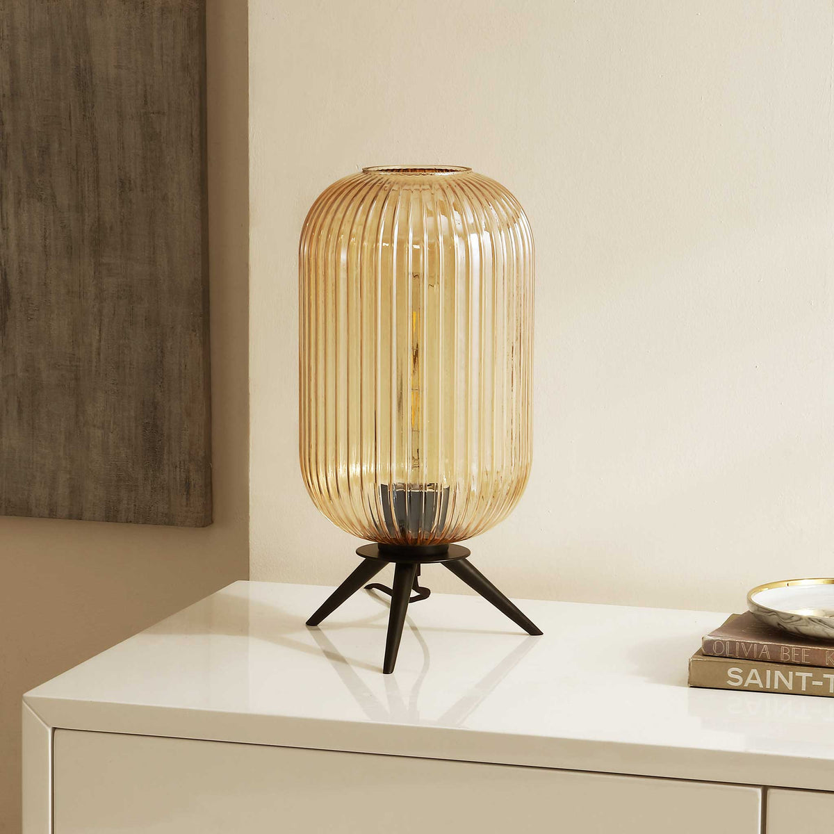 Textured amber glass shade pairs with a minimalist black base for effortless modern style. || TBL4528A || front_angle_room