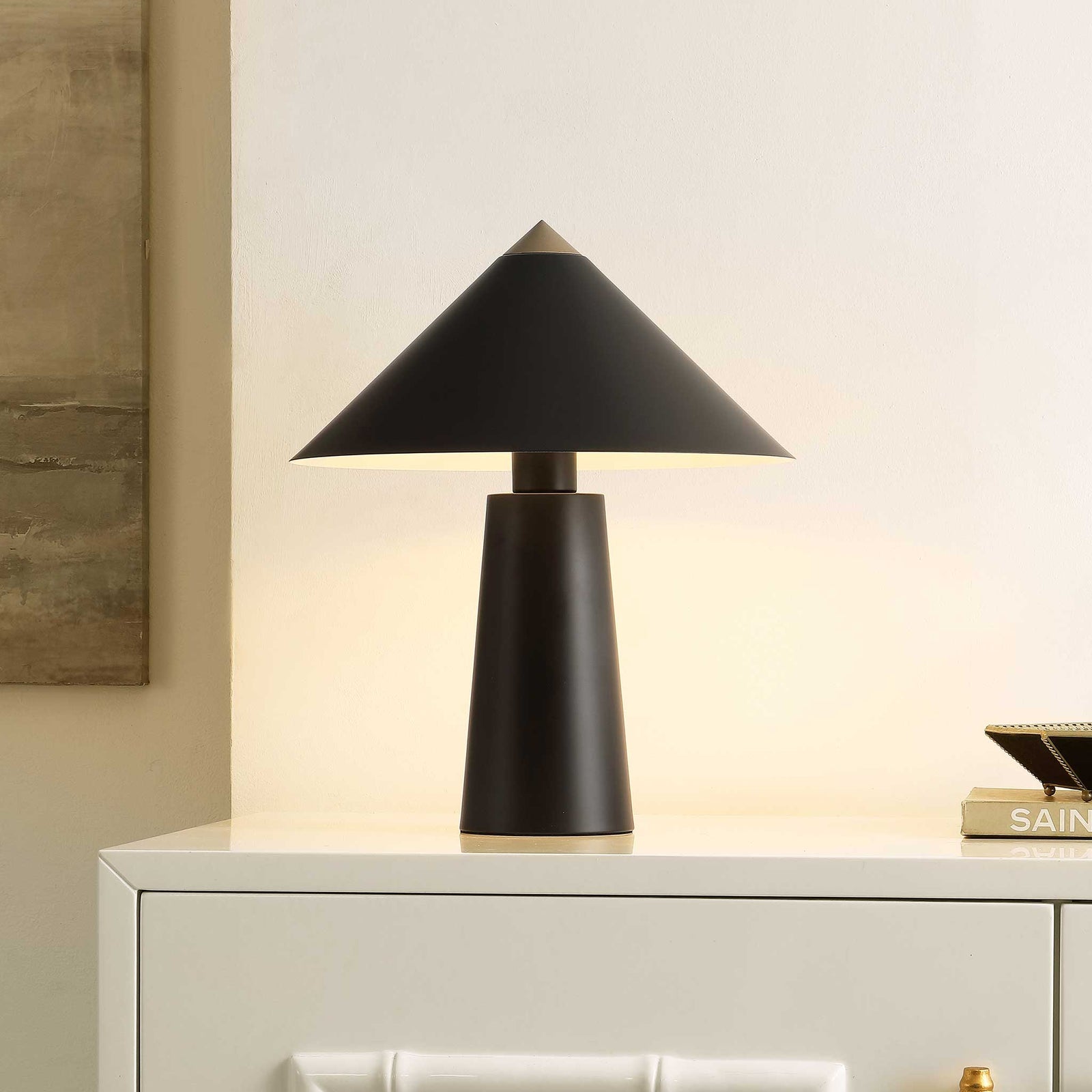 Soft ambient light fills the space as the black and brass lamp anchors a refined modern vignette. || TBL4531A || front_angle_on_room
