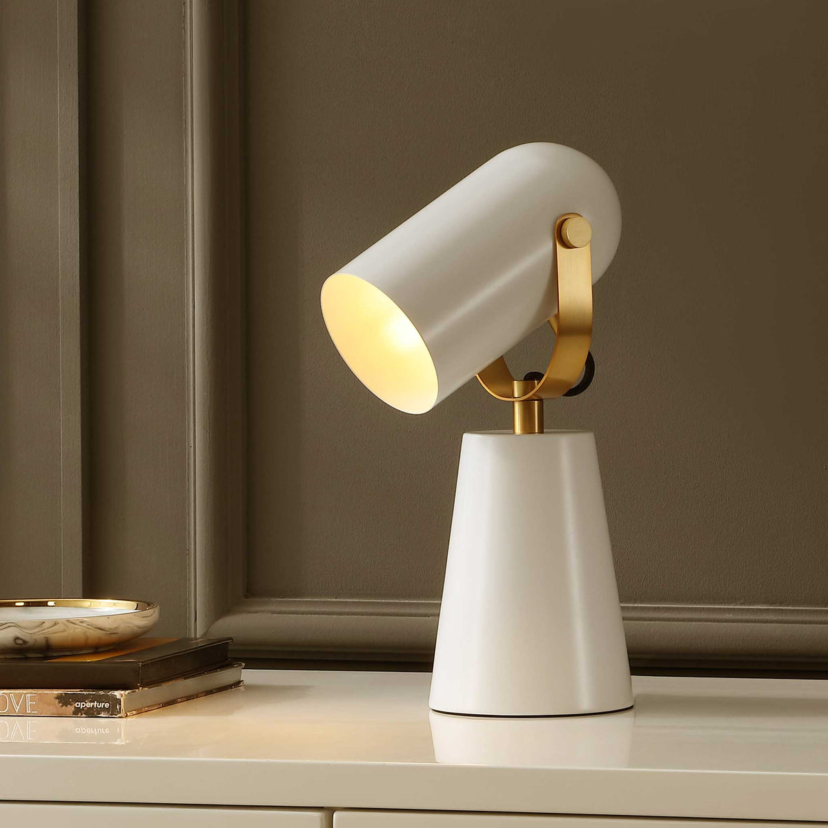 Warm glow radiates from a white metal shade with brass accents, creating a cozy modern accent || TBL4532A || front_angle_on_room