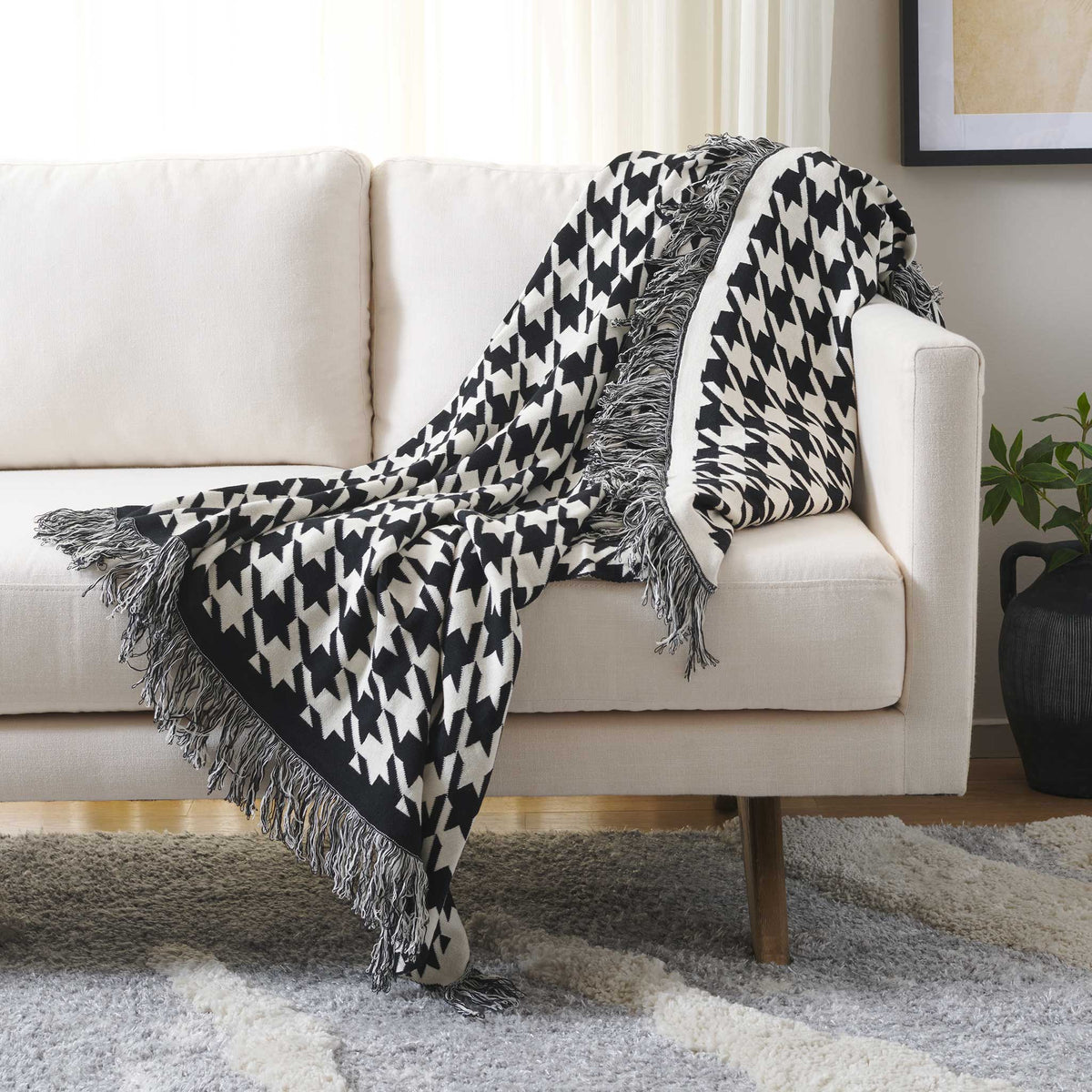 Cozy cotton throw in black and ivory with oversized geometric pattern and tassel fringe