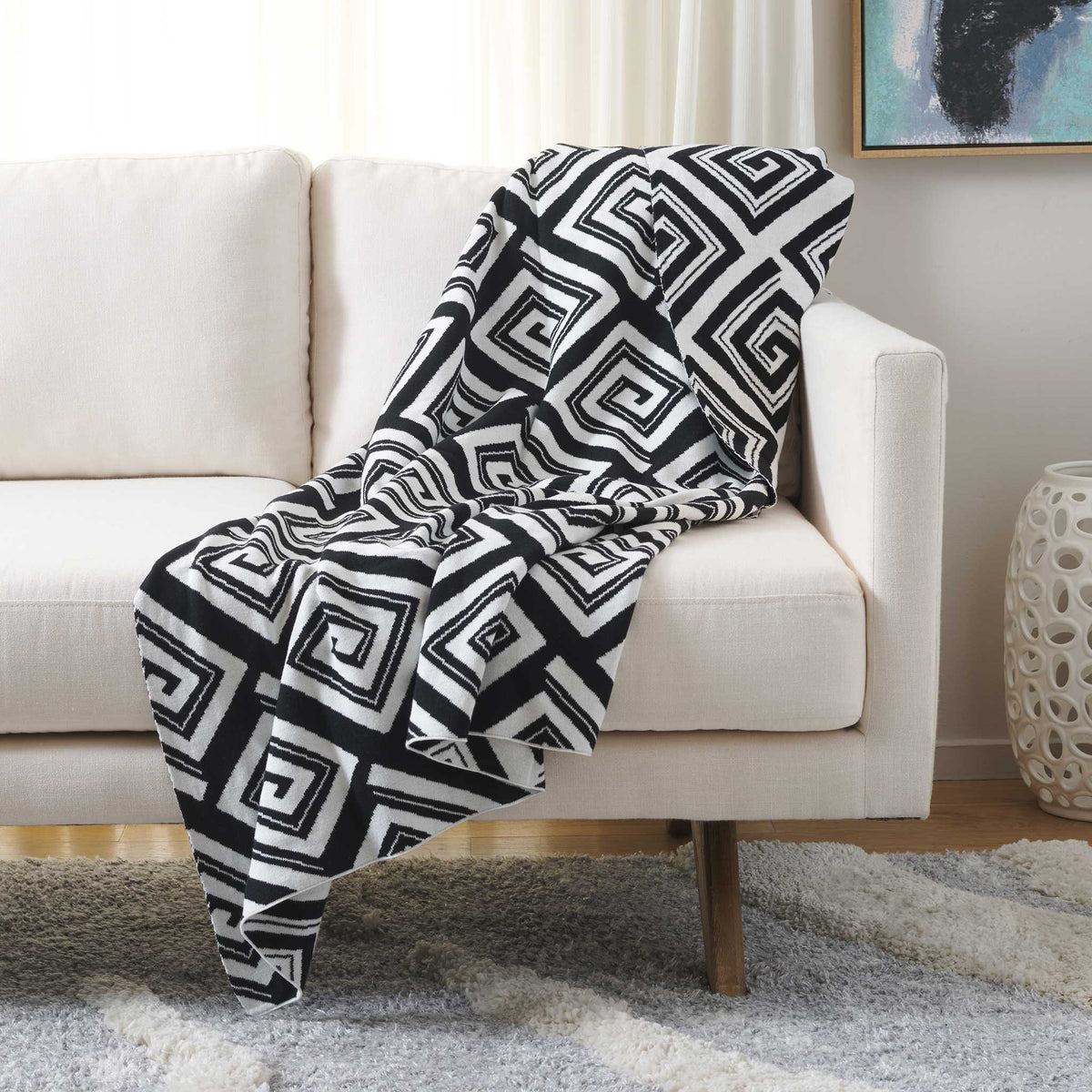 Black and ivory geometric throw draped on a sofa, adding bold contrast and modern flair.