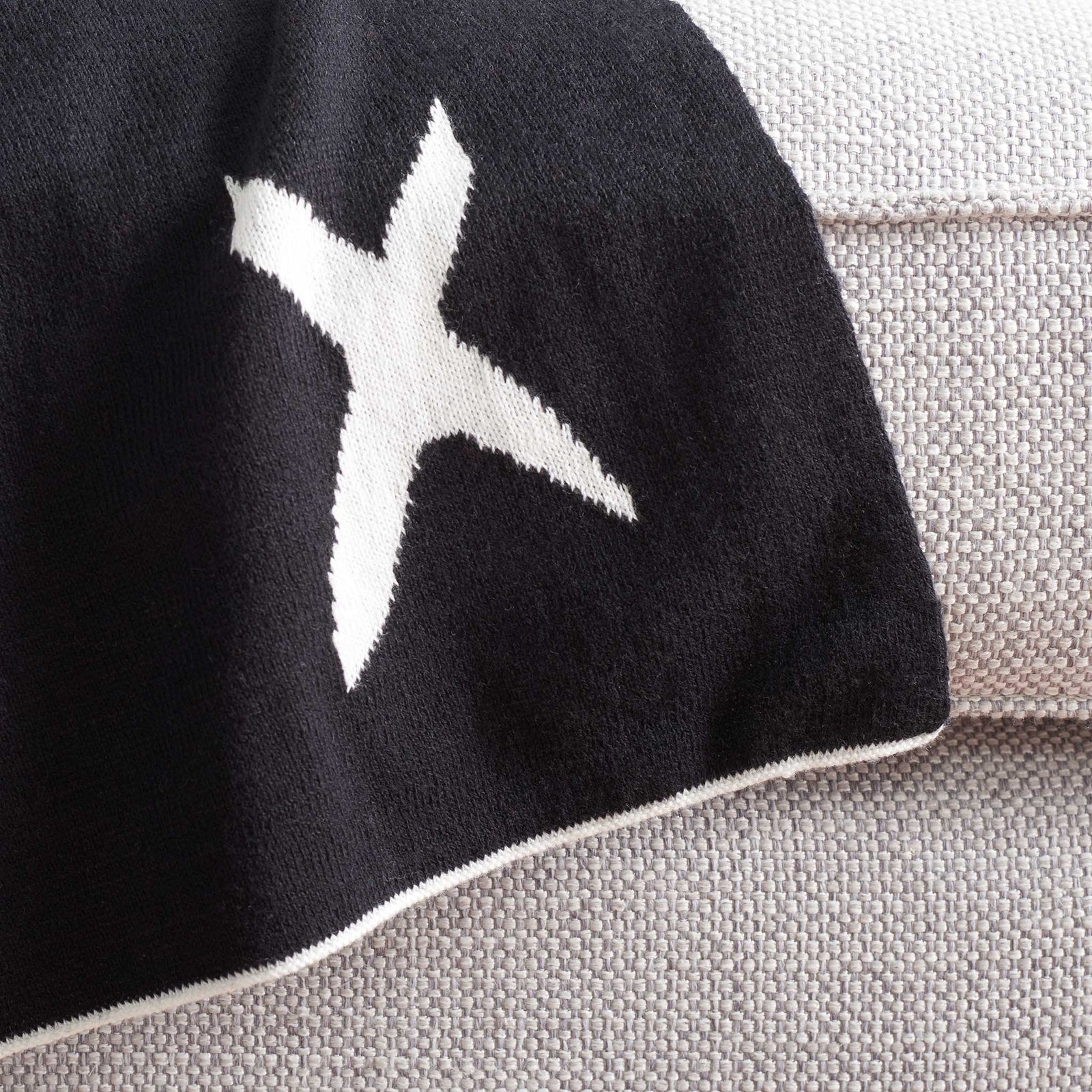 Neatly finished edge and dense knit showcase the quality of this black-and-ivory throw || THR404A-5060 || corner_room