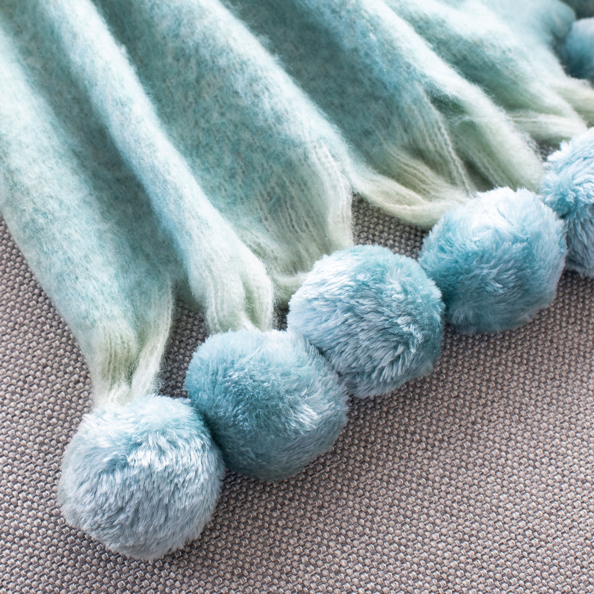 Fluffy blue pom-poms and soft fringe accent the throw's edge || THR619A-5070 || corner_room