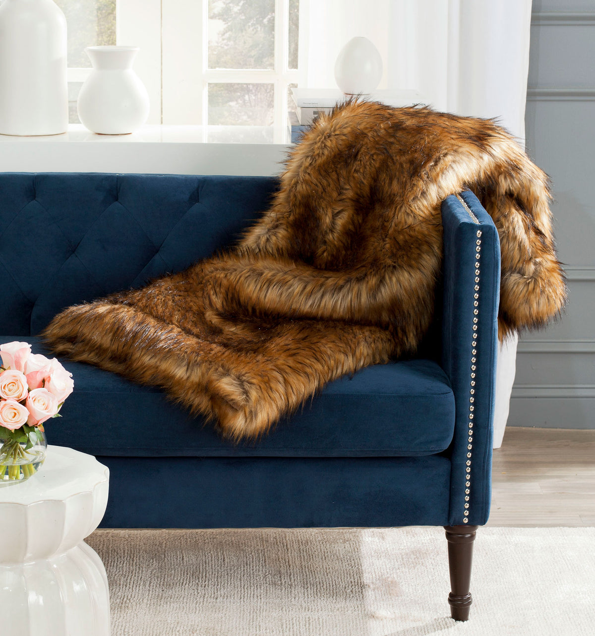 Lush faux fur throw brings inviting warmth and dramatic texture when layered over a sofa arm || THR703A || front_angle_room