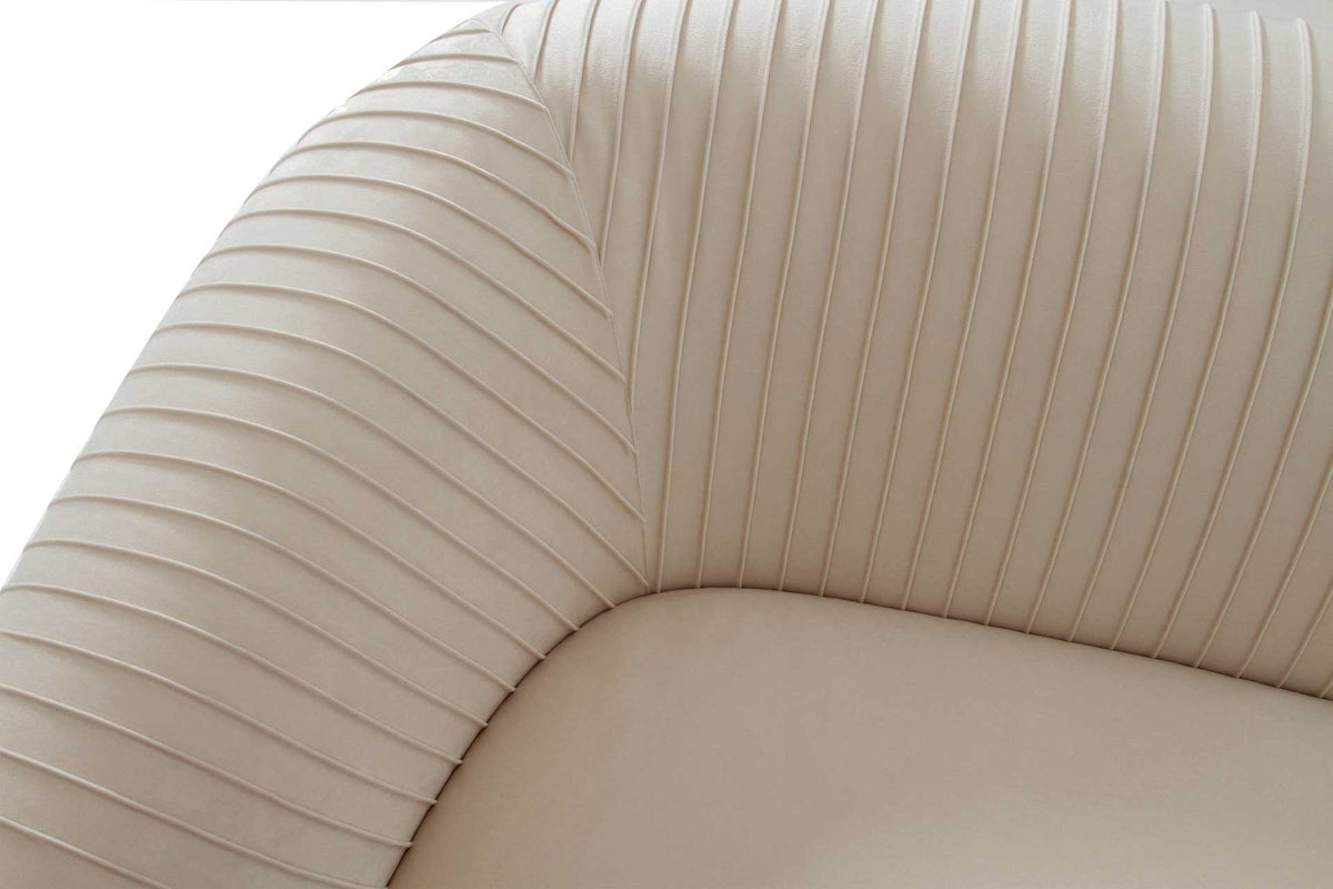 Fine pleats sweep from the rounded arm into the curved back, bringing rich texture to beige velvet