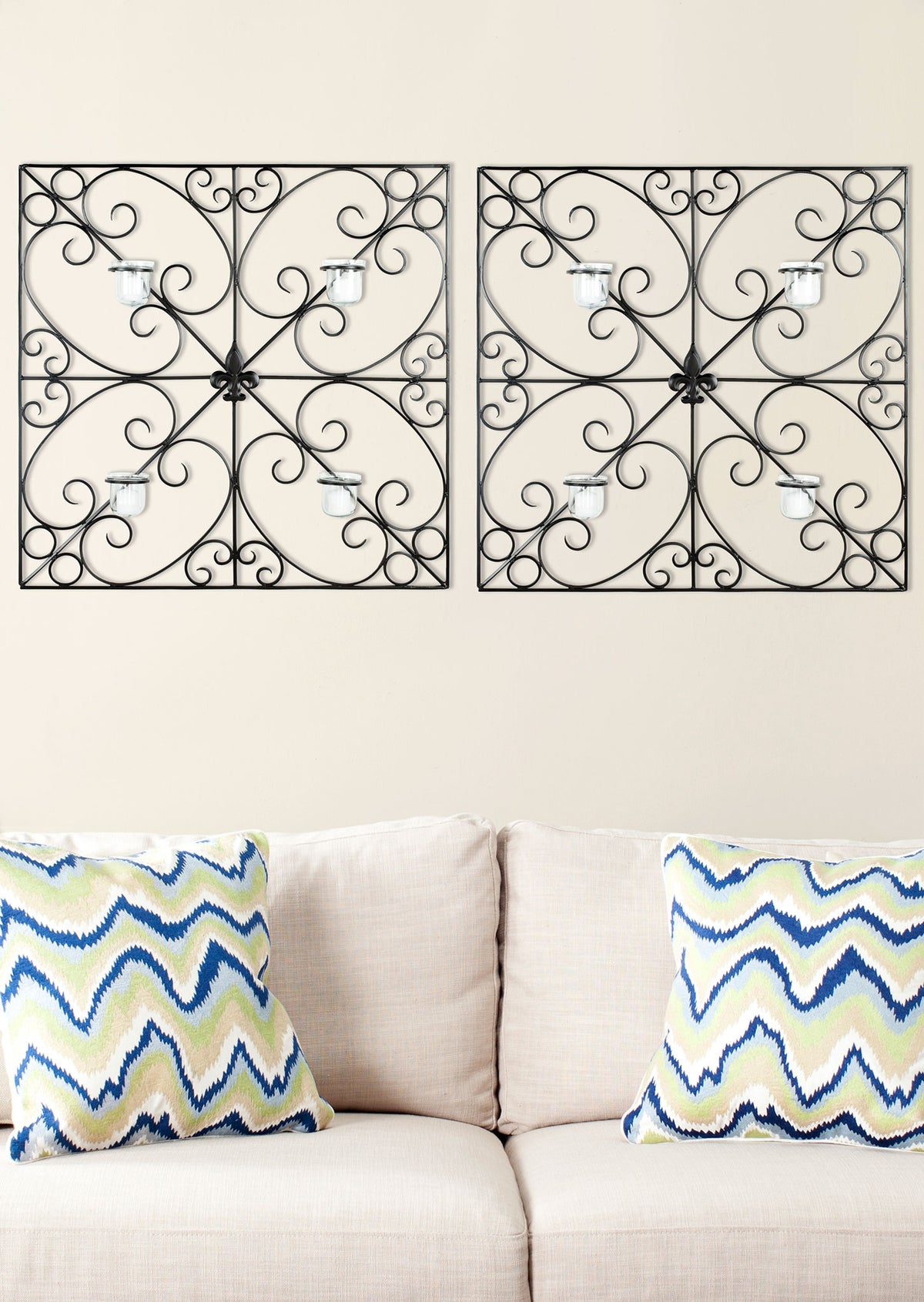 Two ornate black iron wall accents pair scrolling frames with four glass votives apiece. || WDC1005A || front_room